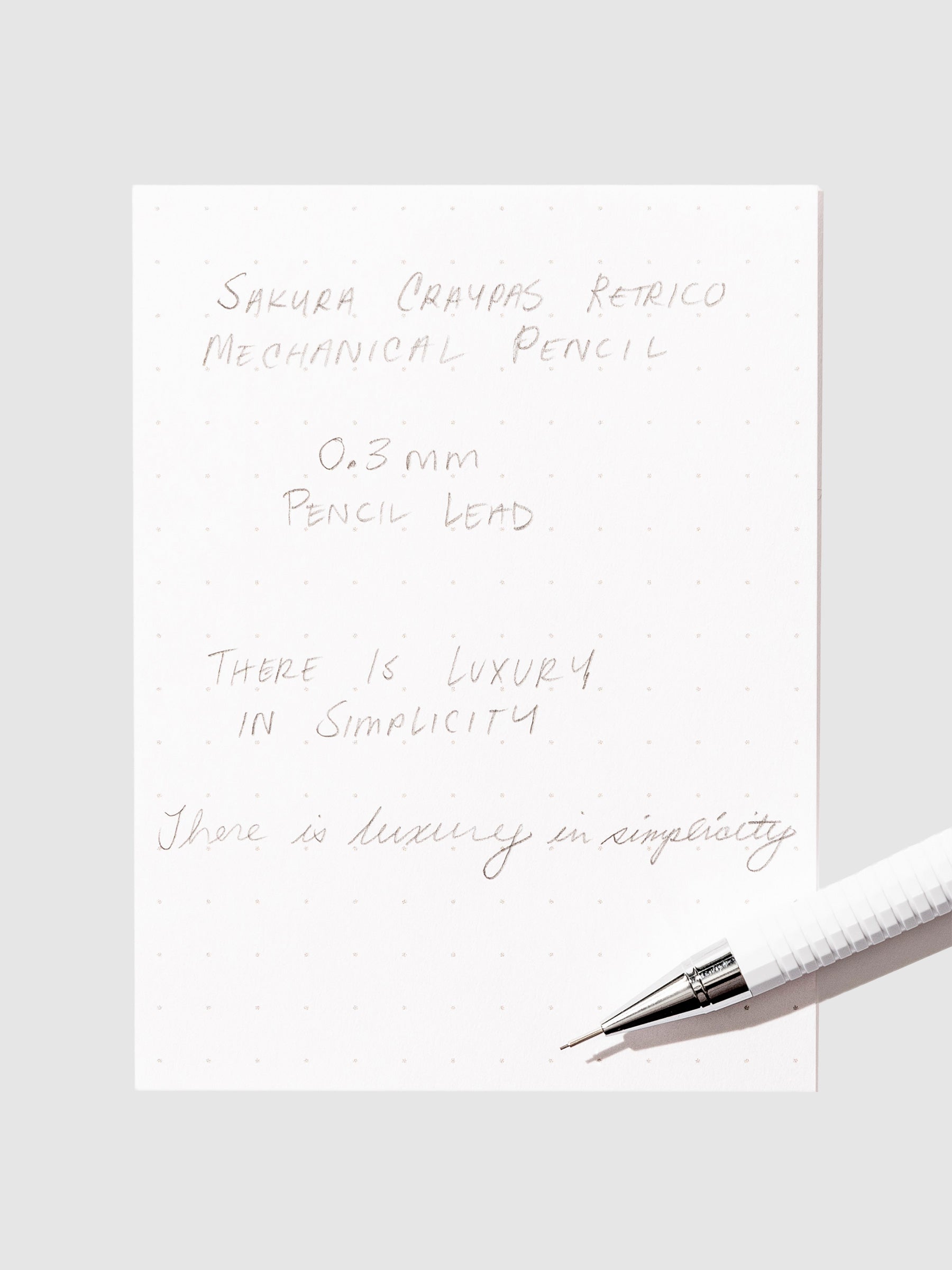 Writing sample with pencil displayed on a neutral background.