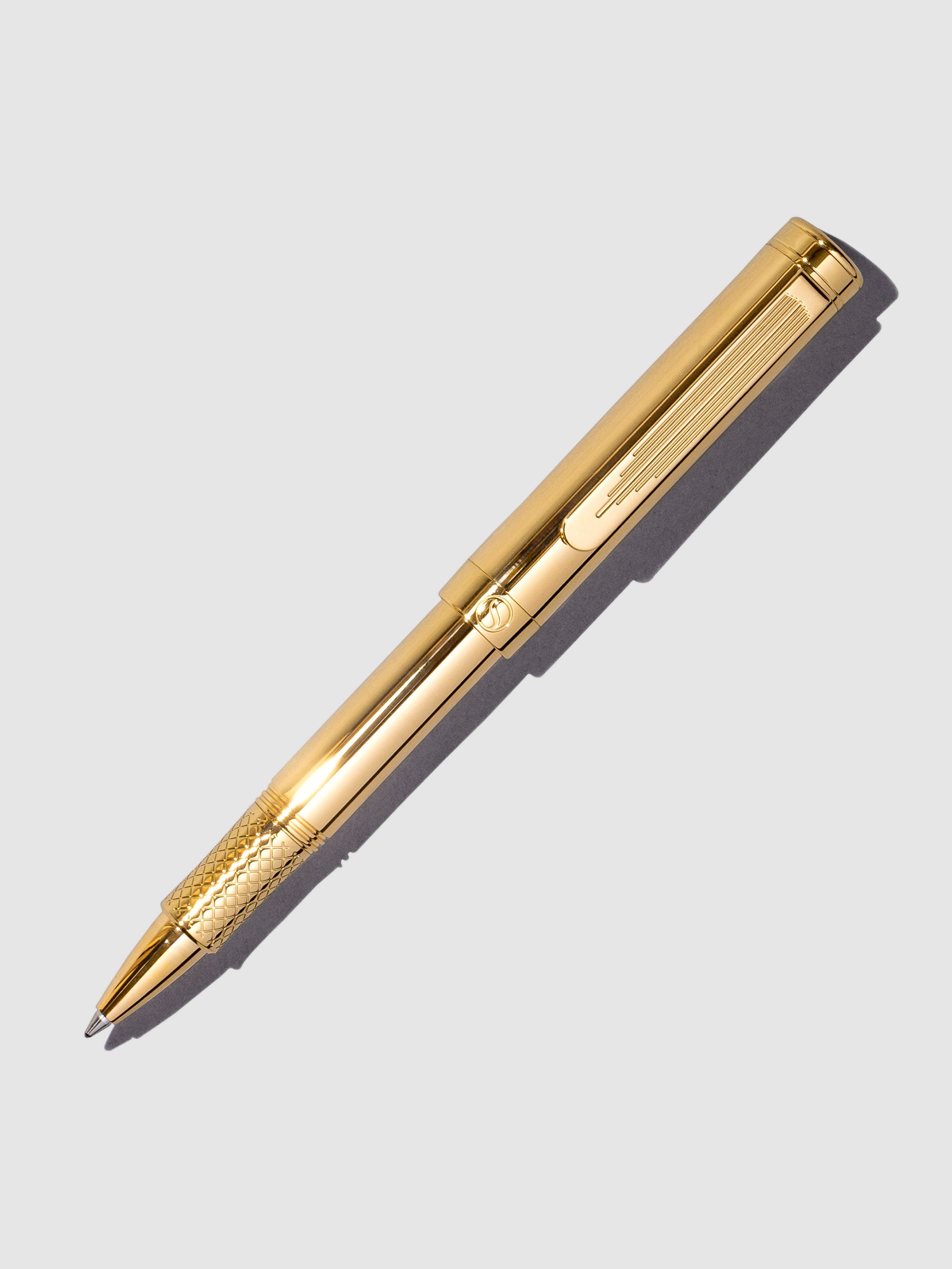 Scriveiner EDC Rollerball Pen, Gold, Cloth and Paper. Pen displayed on a neutral background.