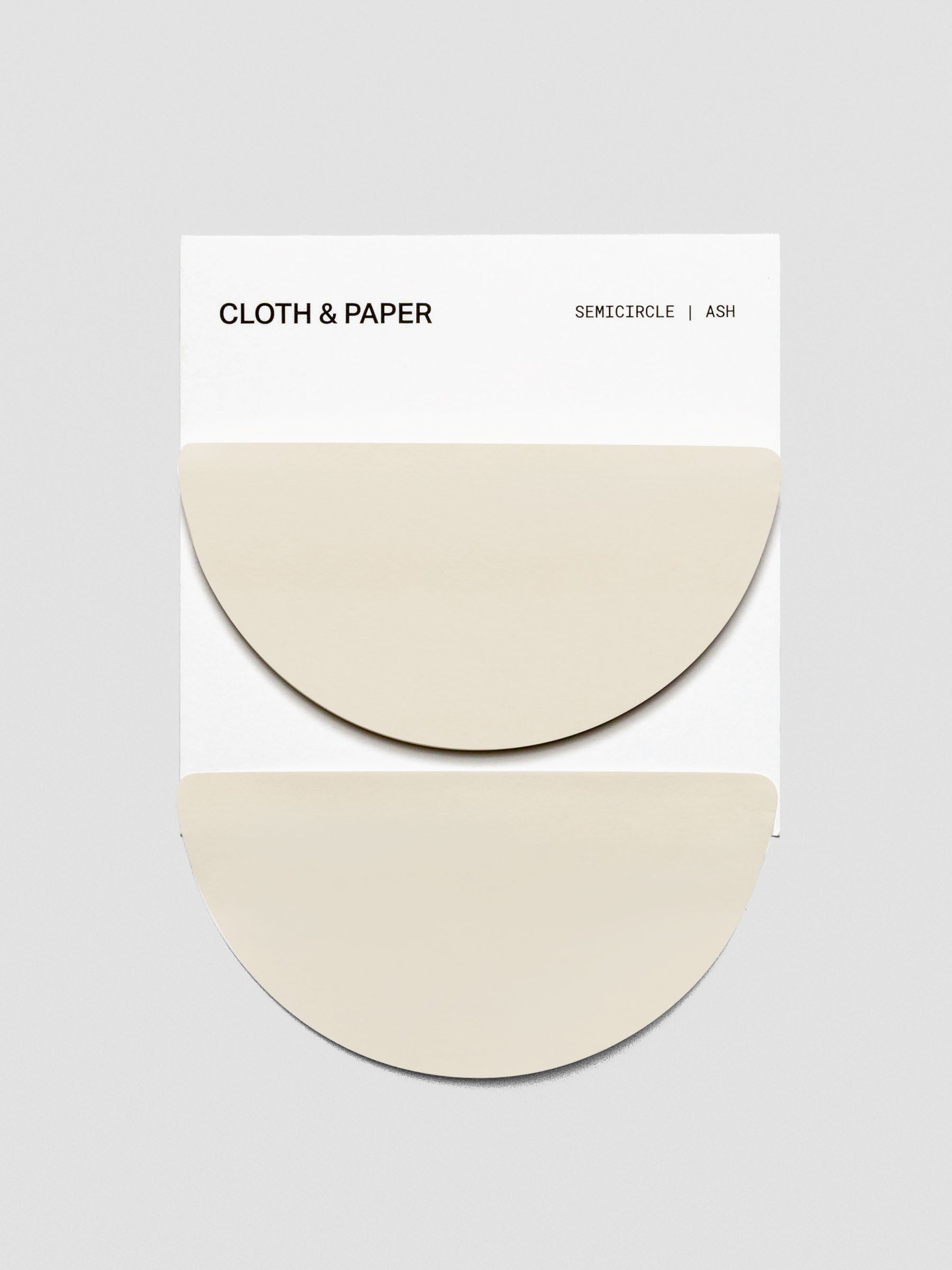 Cloth & Paper Semicircle Sticky Notes in Ash displayed on a white backing card. Two overlapping half-circle sticky note pads are shown in a soft beige tone.
