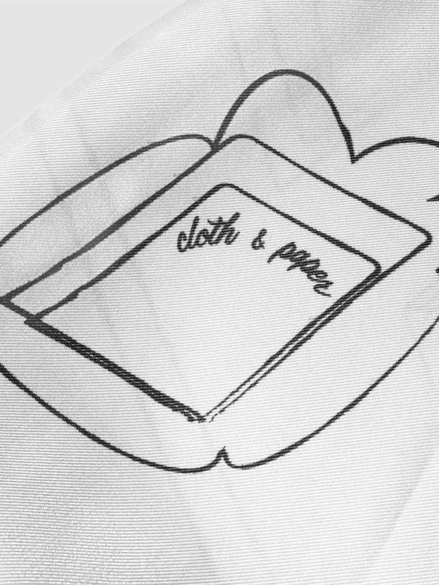 Closeup of printed design on scarf featuring architectural elements and handwritten text that reads "Cloth and Paper"