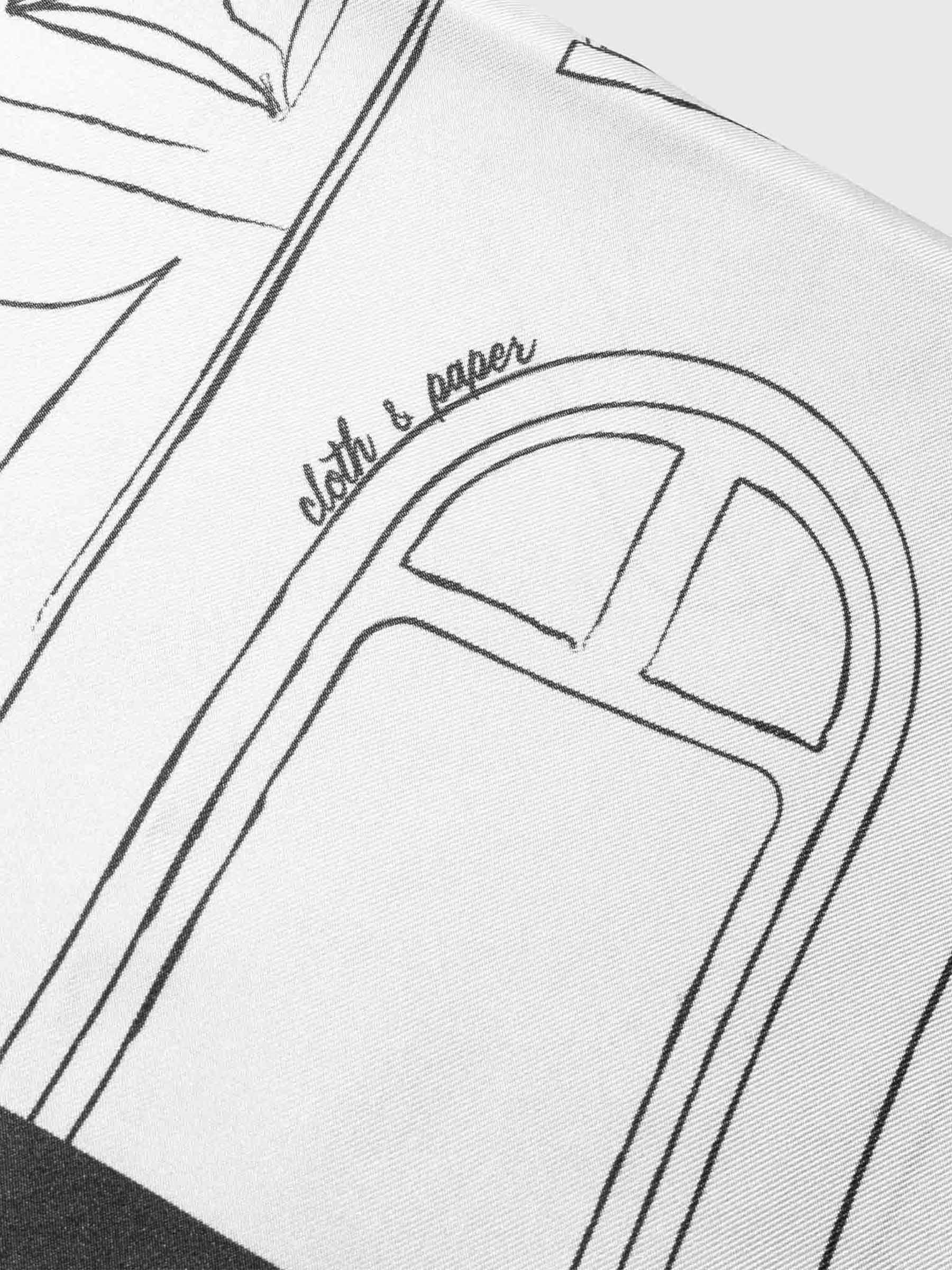 Closeup of printed design on scarf. An archway with handwritten text reading "Cloth & Paper" is the focus of the image.