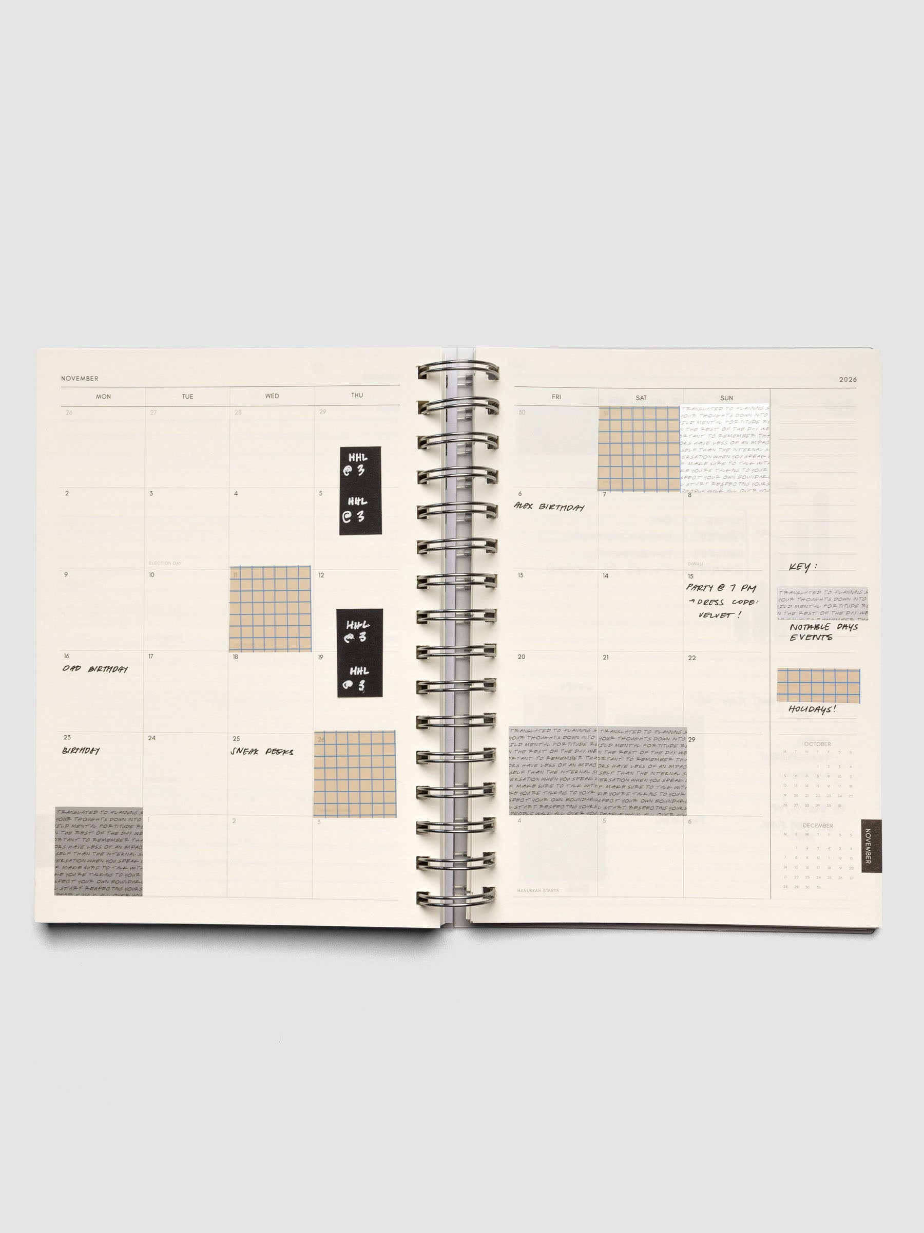 Open spiral notebook with Square Page Flag Set Vol. 1 shown in use on a monthly layout.