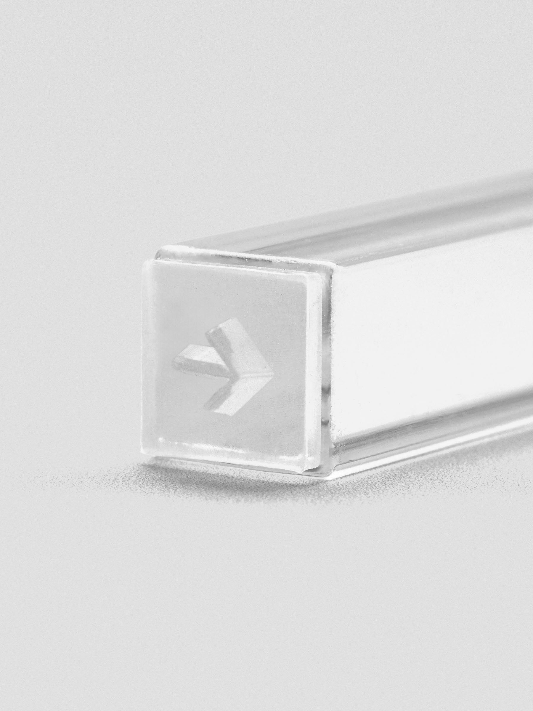 Close-up of stamp stick end showing an engraved arrow icon.