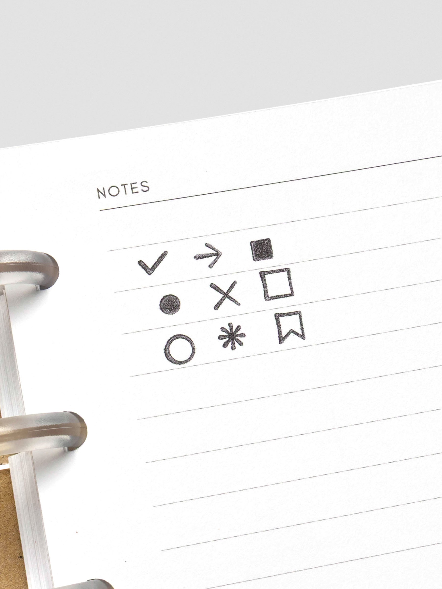 Sample stamped icons on white planner paper, showing all nine designs in black ink.