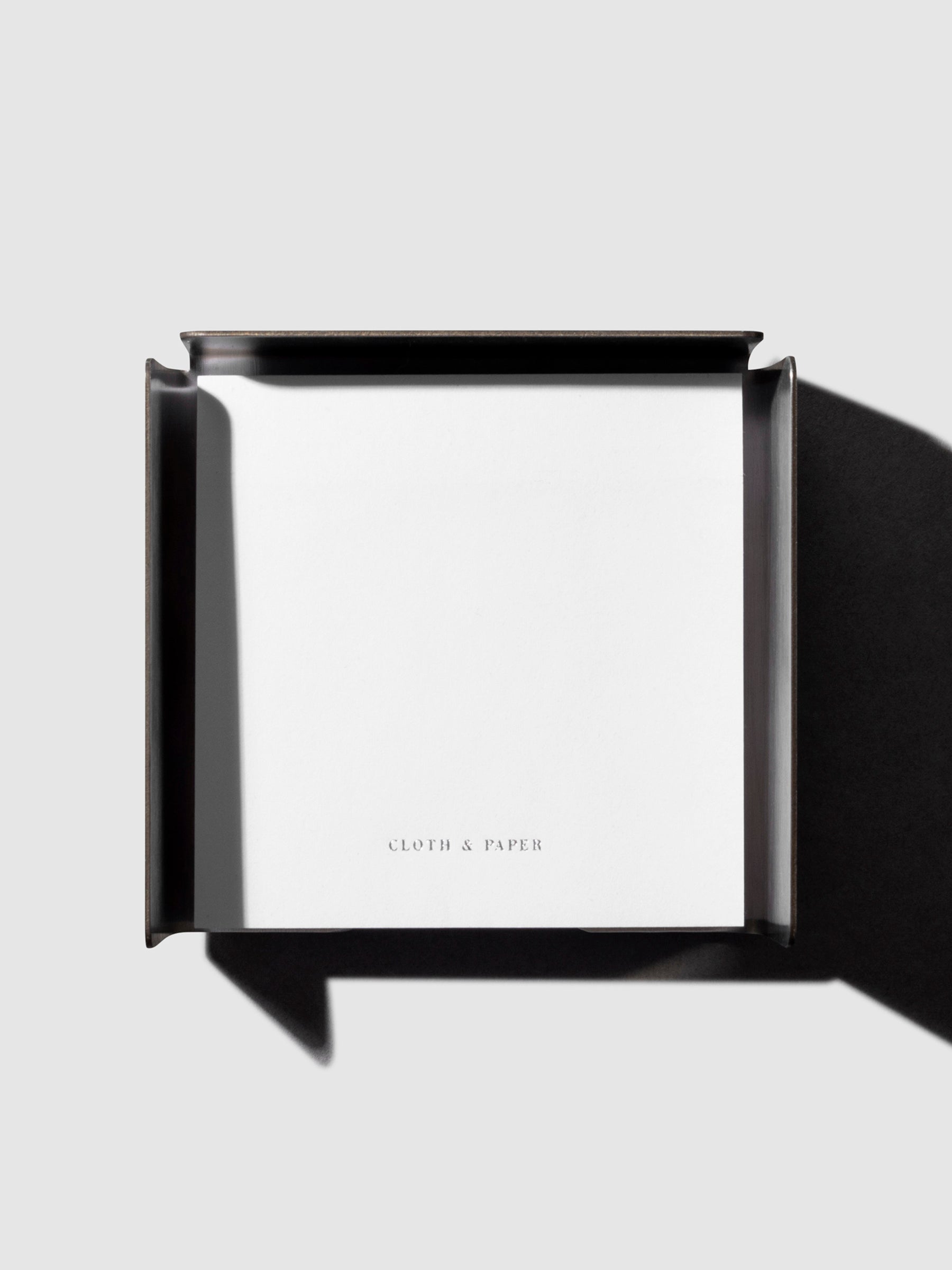 Sticky note holder displayed on a neutral background with sticky note placed inside.