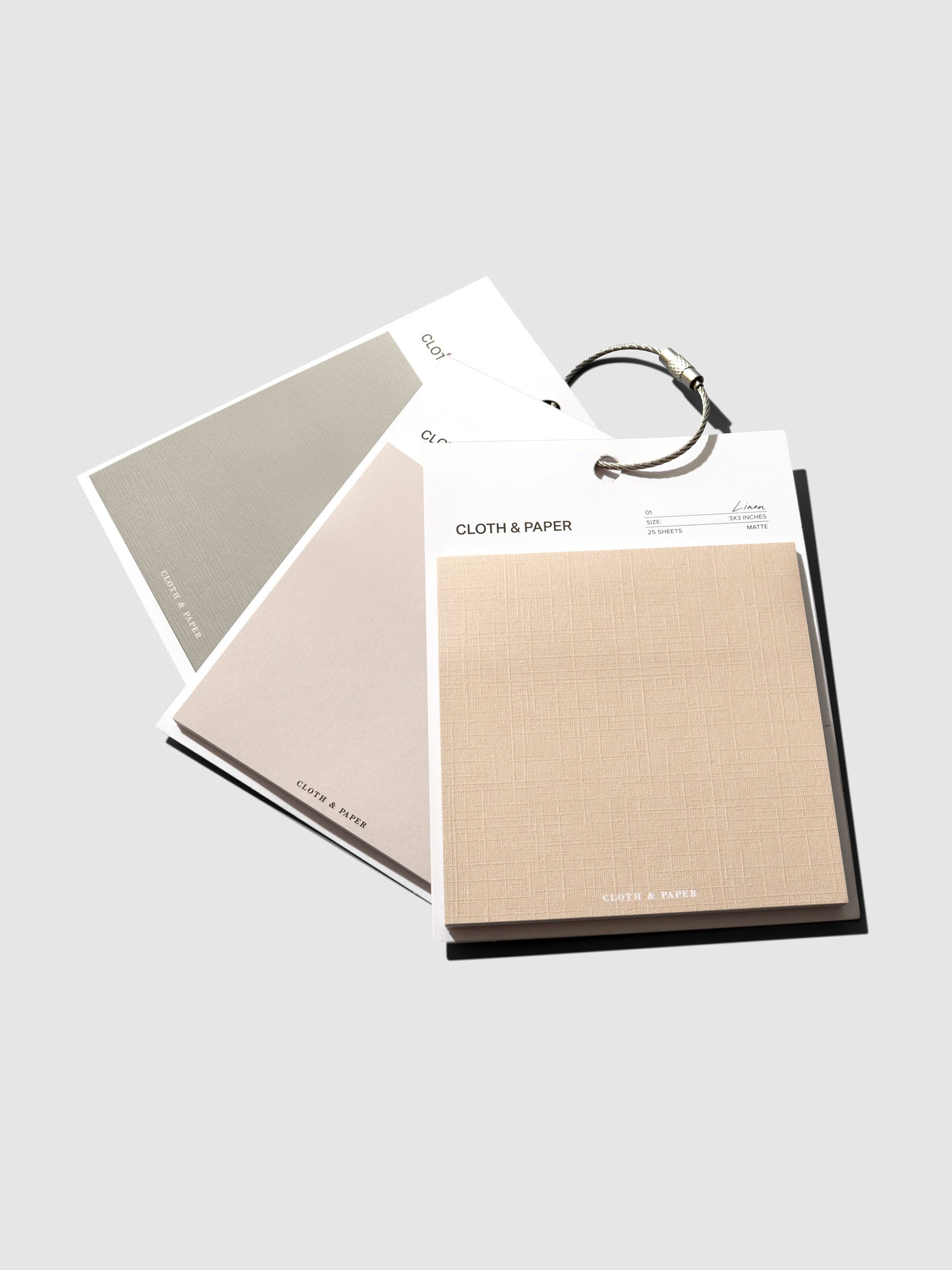 Earl Grey, Ibiza, and Angora sticky notes clipped together with a metal ring on a neutral background.