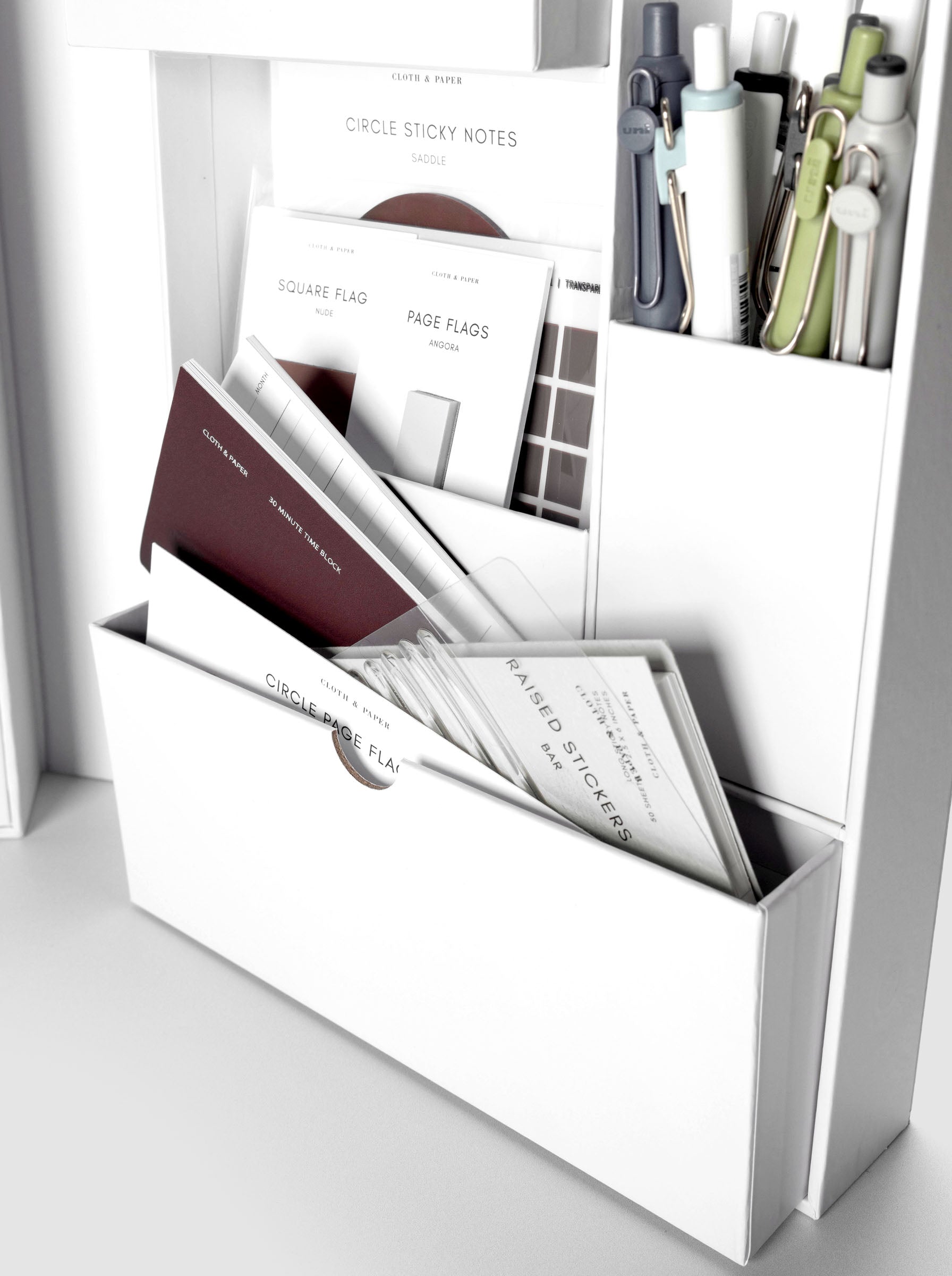 Storage Book 4.0 close up of interior compartment drawer with small travel notebook, stickers, and accessories inside.