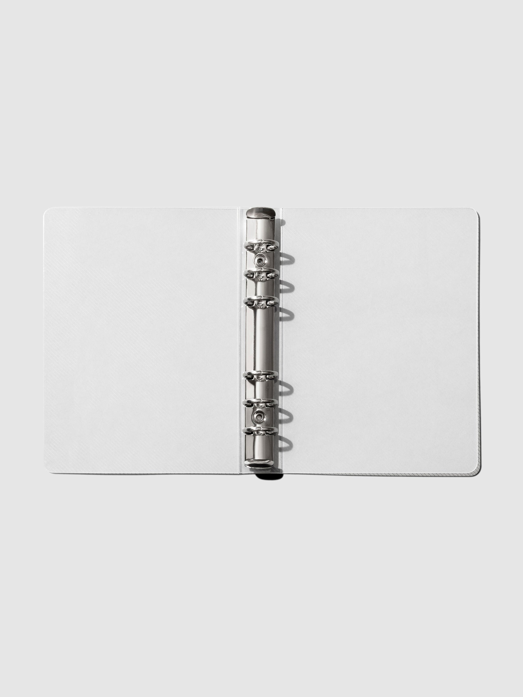 Open, flat Transparent Binder in size Personal with silver 6-ring binding.