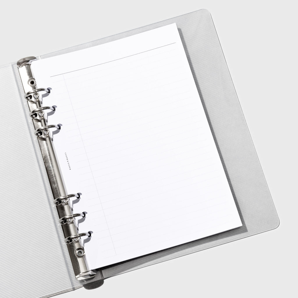 Binder displayed open with a planner insert inside of it.