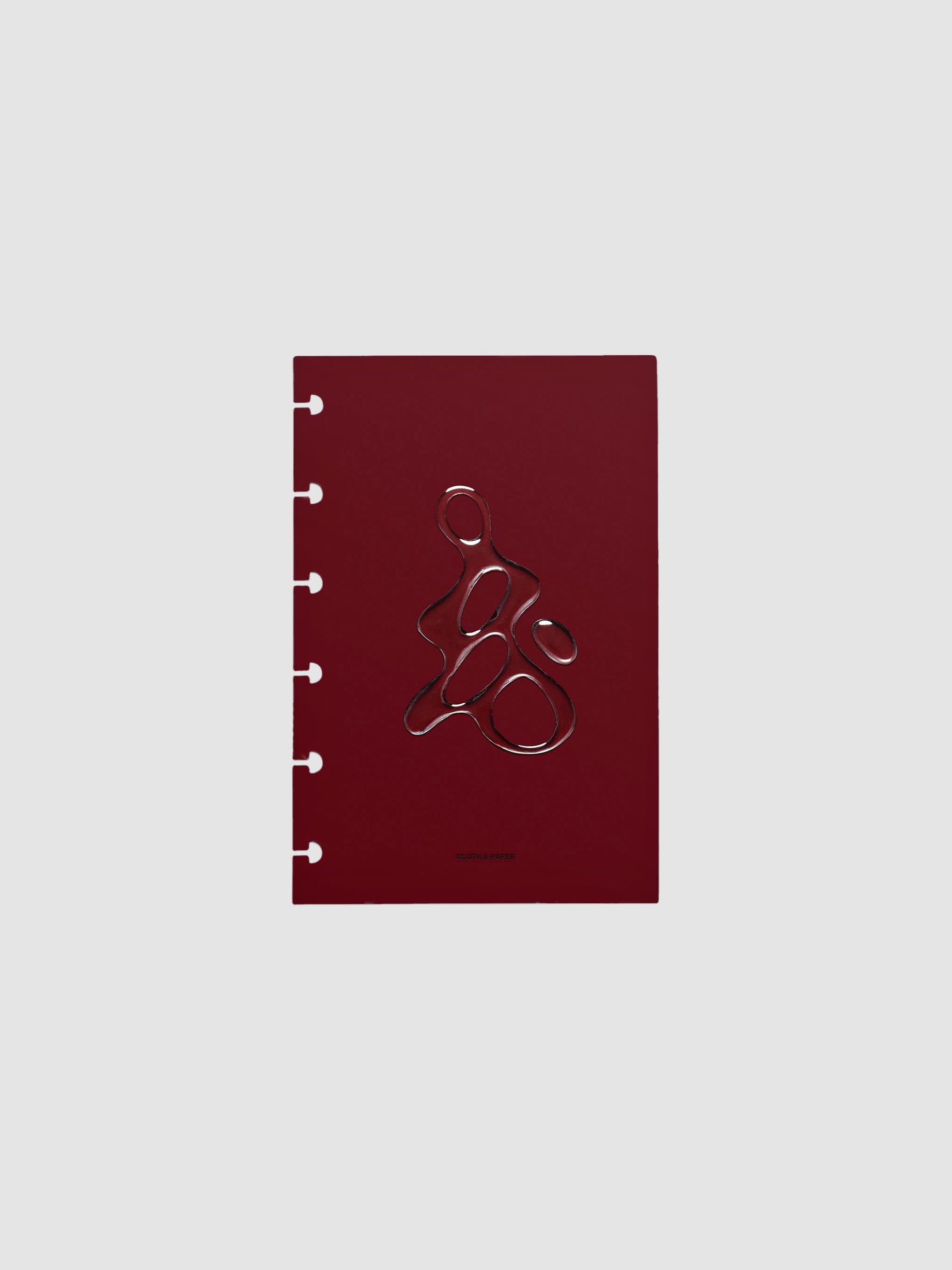 Dark red, semi-transparent, and glossy plastic planner dashboard with organic raised shape design in size CP Petite on a neutral background.