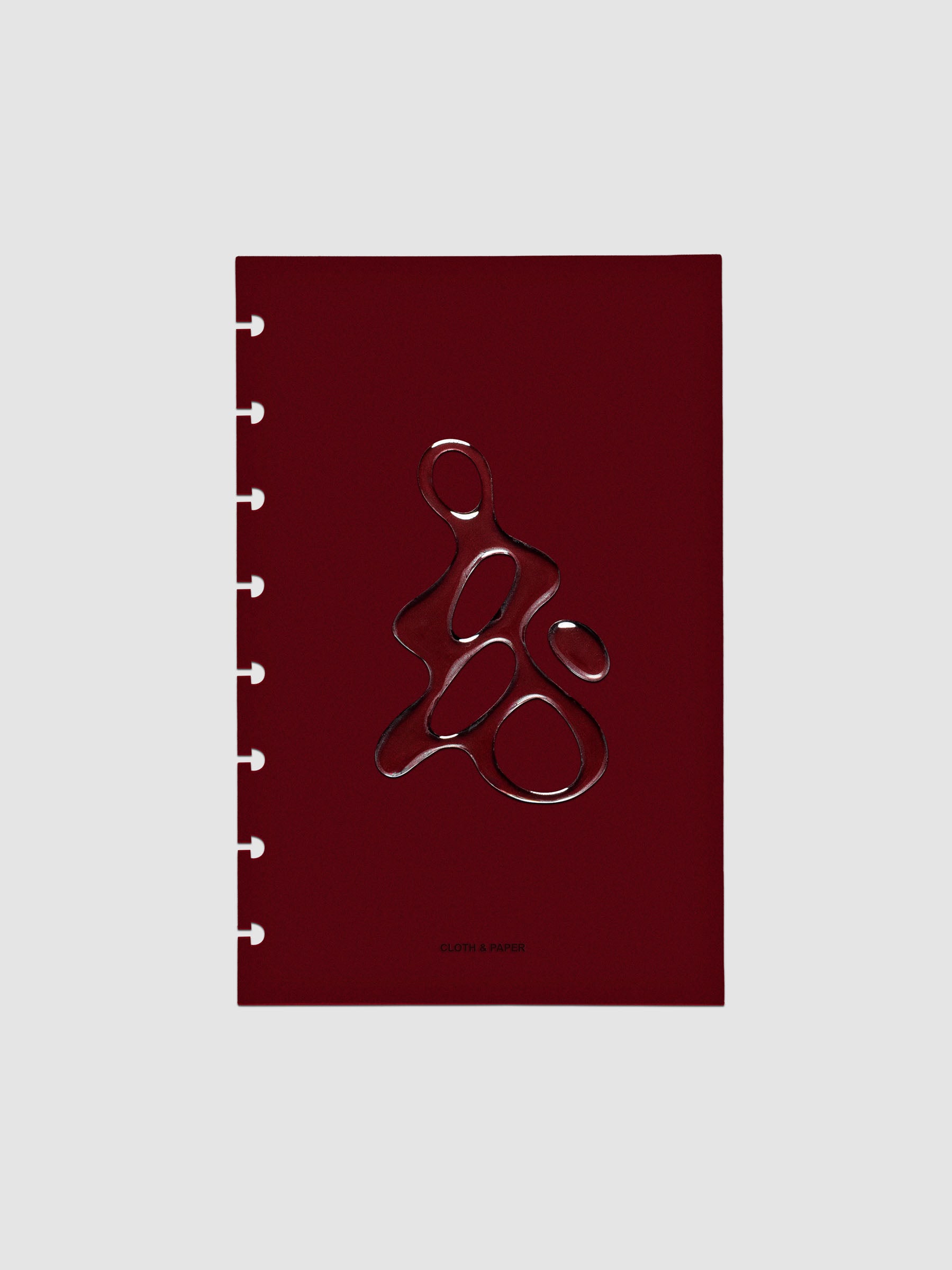 Dark red, semi-transparent, and glossy plastic planner dashboard with organic raised shape design in size Half Letter on a neutral background.