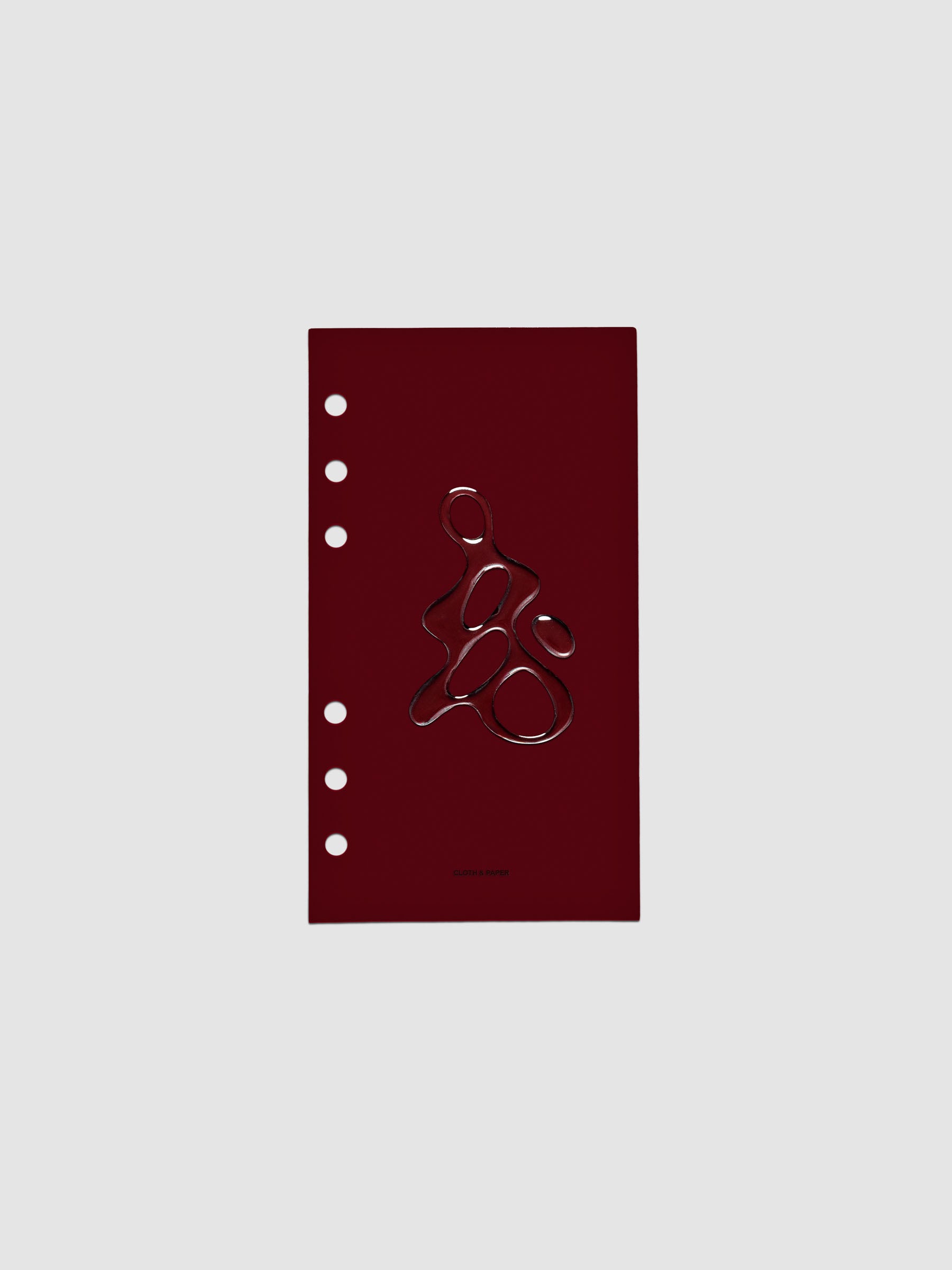 Dark red, semi-transparent, and glossy plastic planner dashboard with organic raised shape design in size Personal on a neutral background.