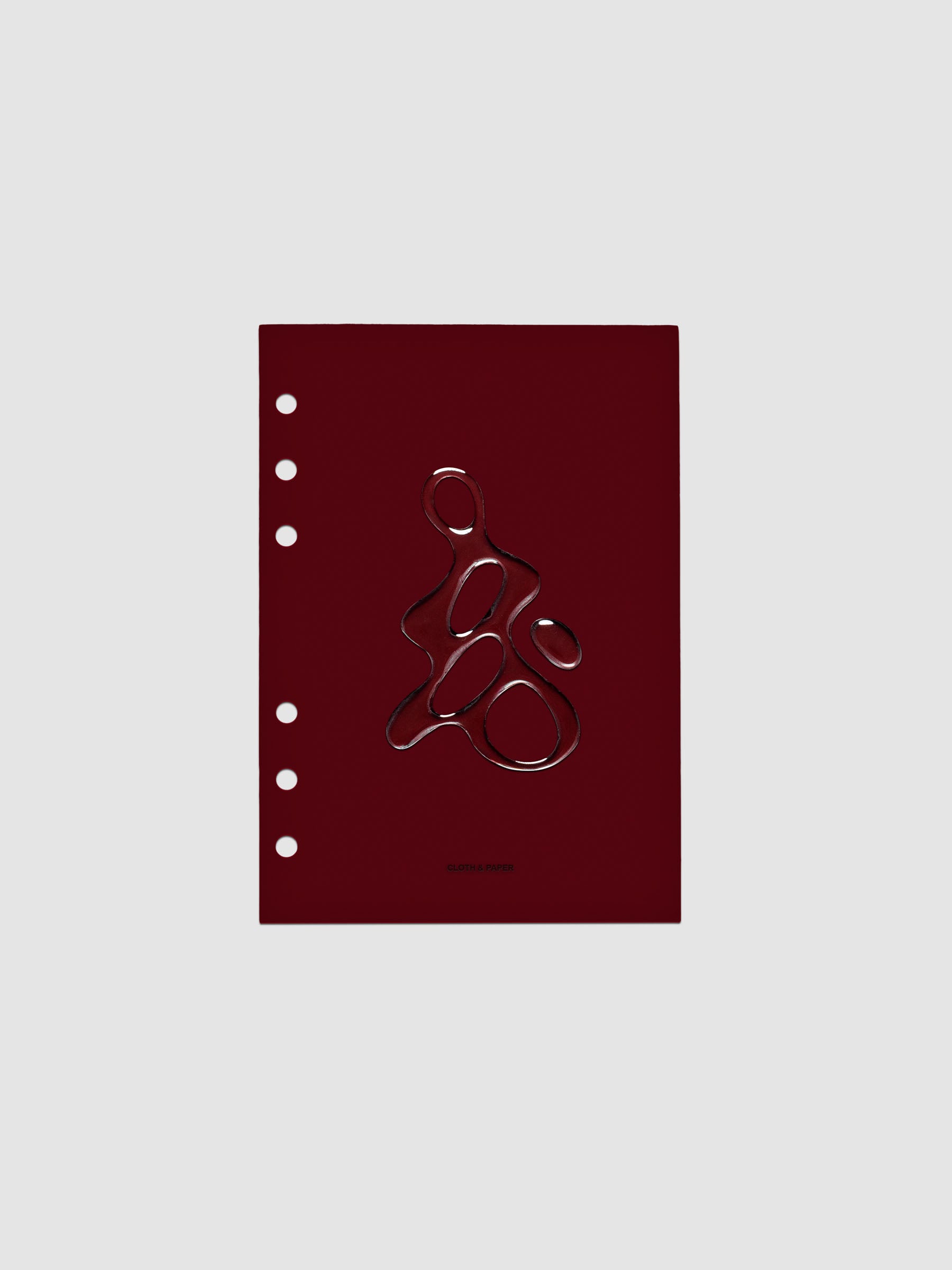 Dark red, semi-transparent, and glossy plastic planner dashboard with organic raised shape design in size Personal Wide on a neutral background.