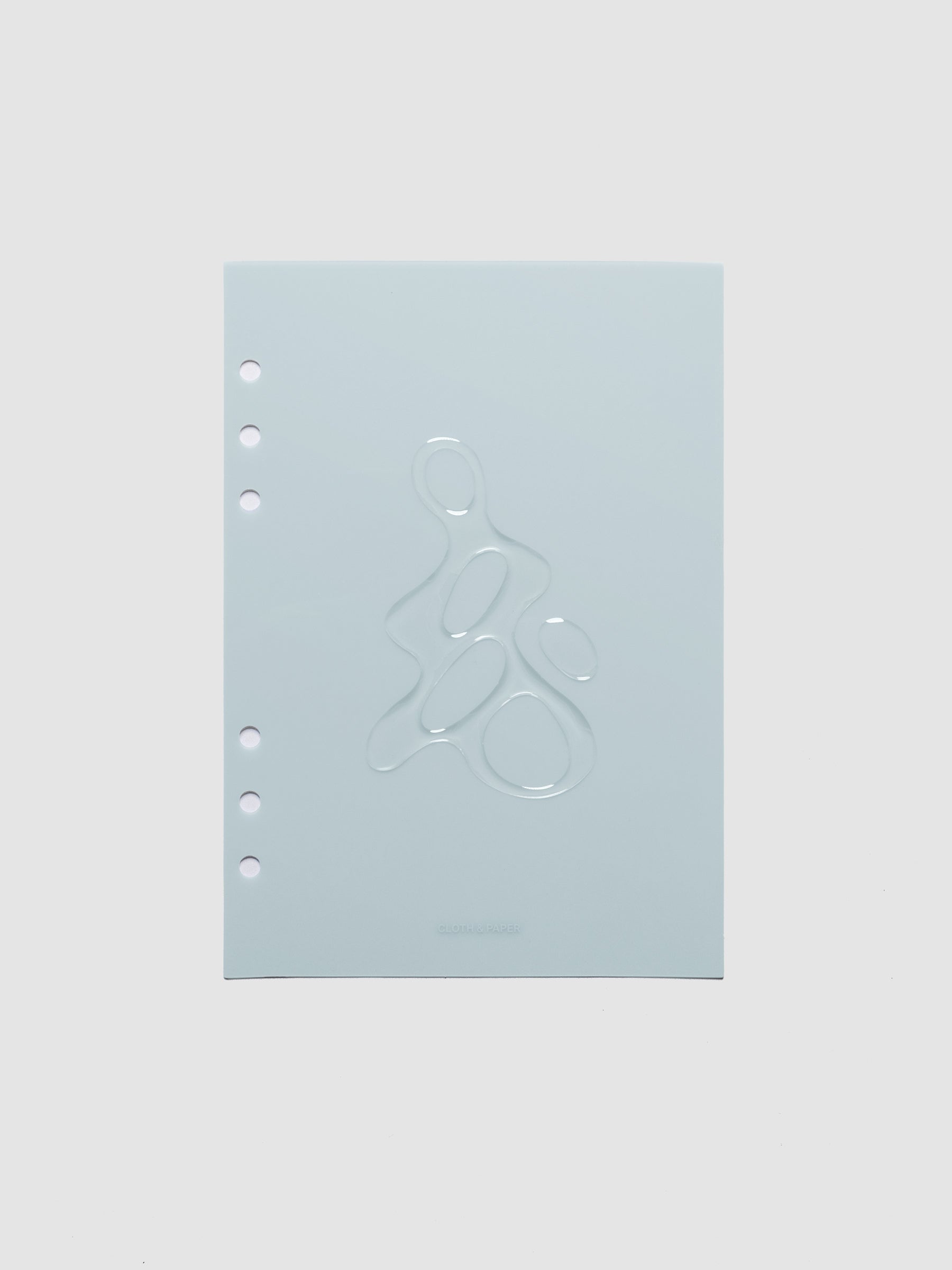 Light blue, semi-transparent, and glossy plastic planner dashboard with organic raised shape design in size A5 on a neutral background.