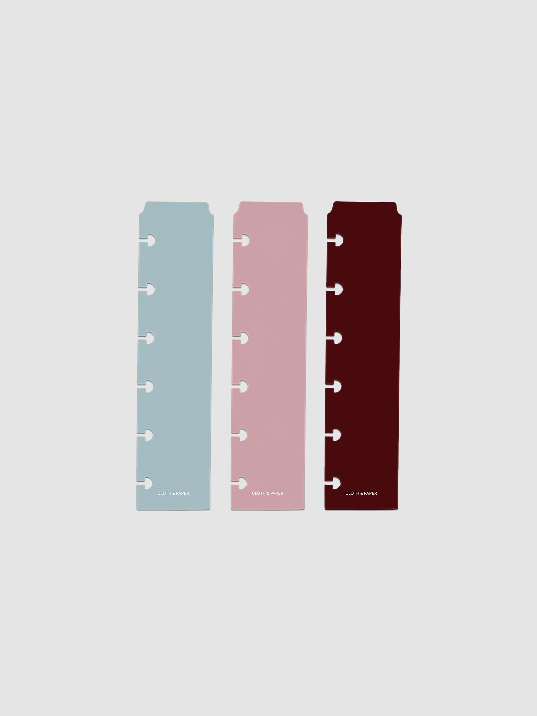 Set of three narrow page markers pre-punched for CP Petite planners in light blue, pink, and burgundy on a neutral background.