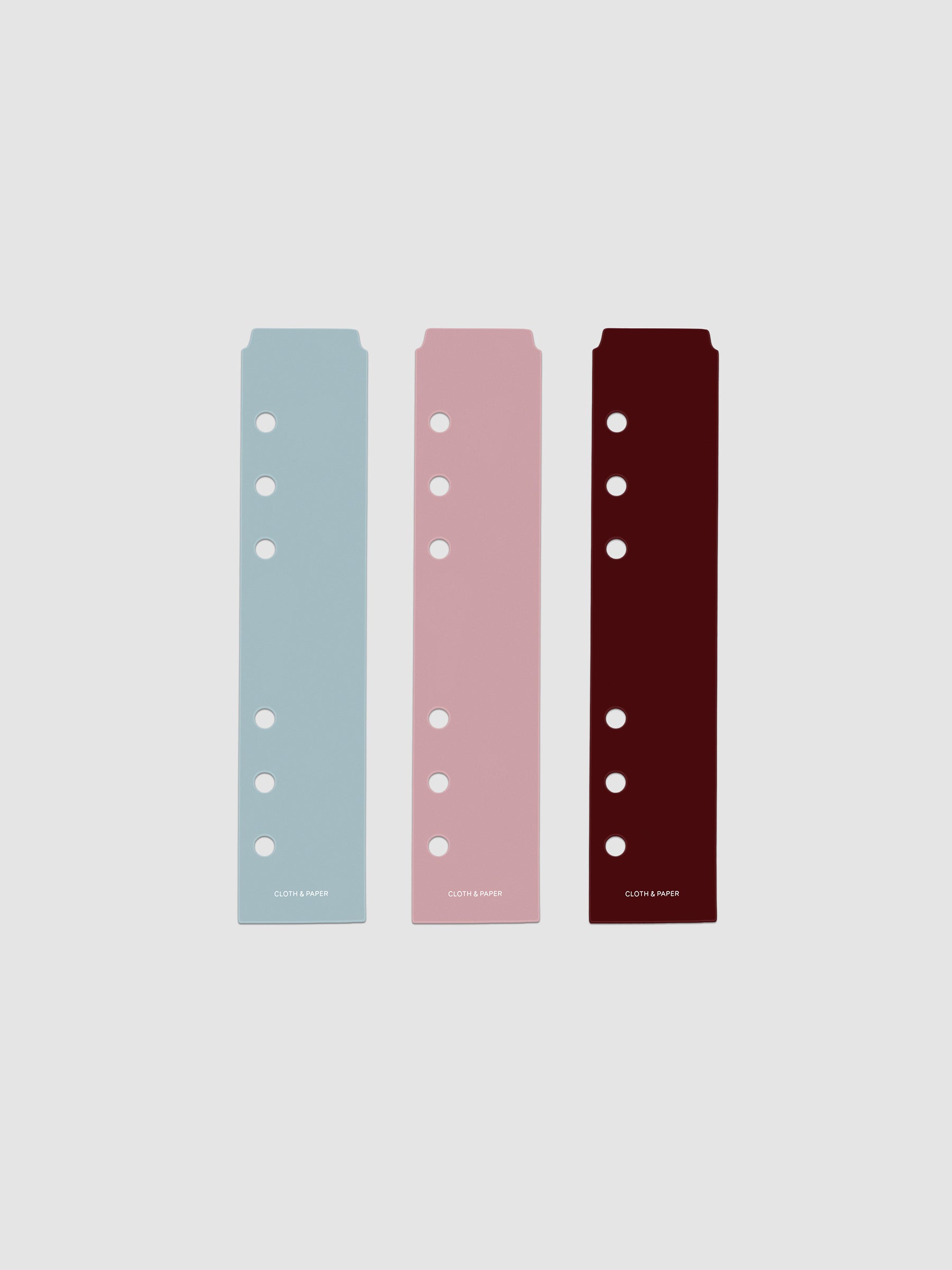 Set of three narrow page markers pre-punched for Personal and Personal Wide planners in light blue, pink, and burgundy on a neutral background.