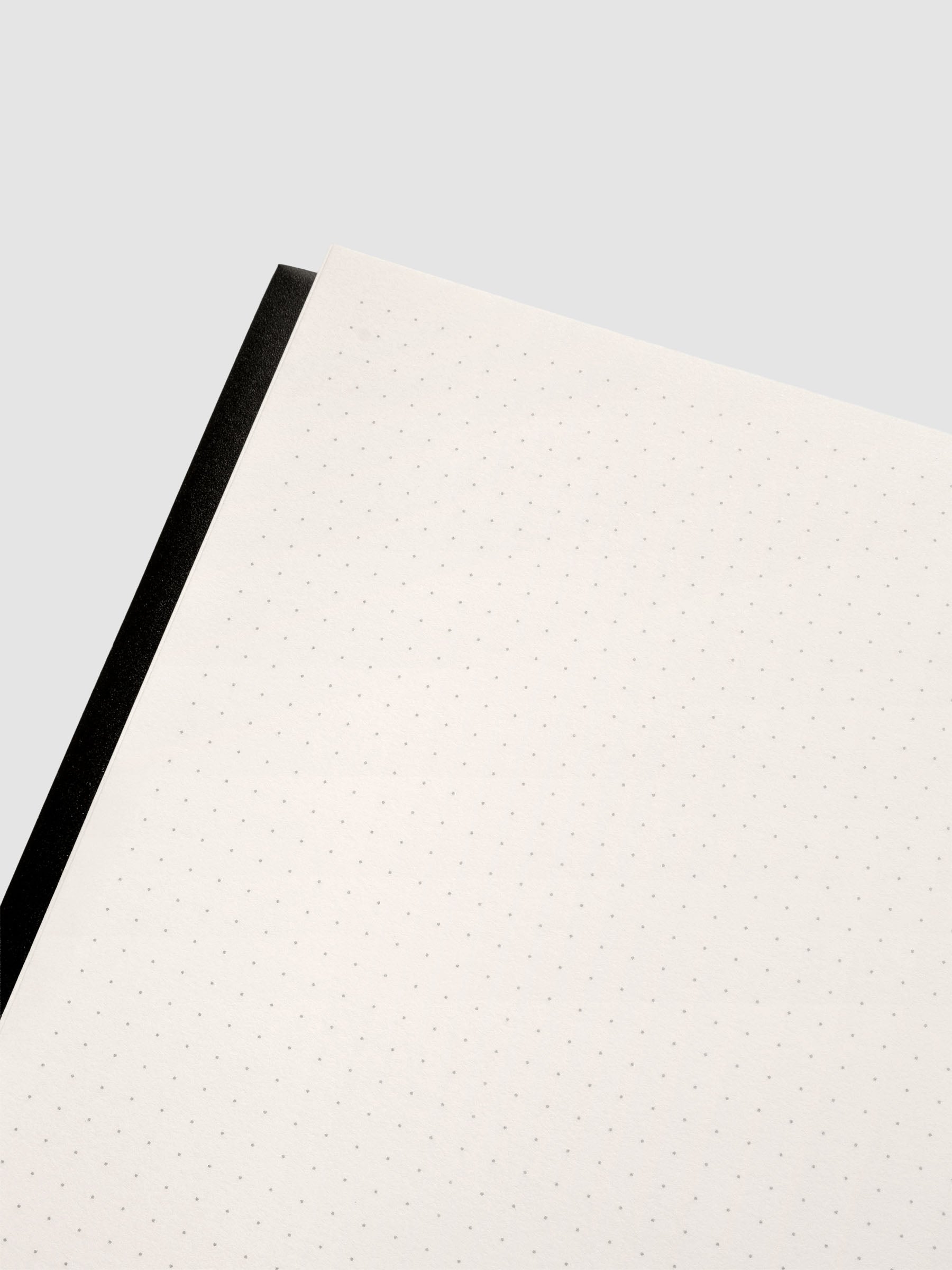 Close up of the Perfect Bound Notebook | A5 | Dot Grid | Avant Garde shown open, laying flat, displaying the dot grid layout.