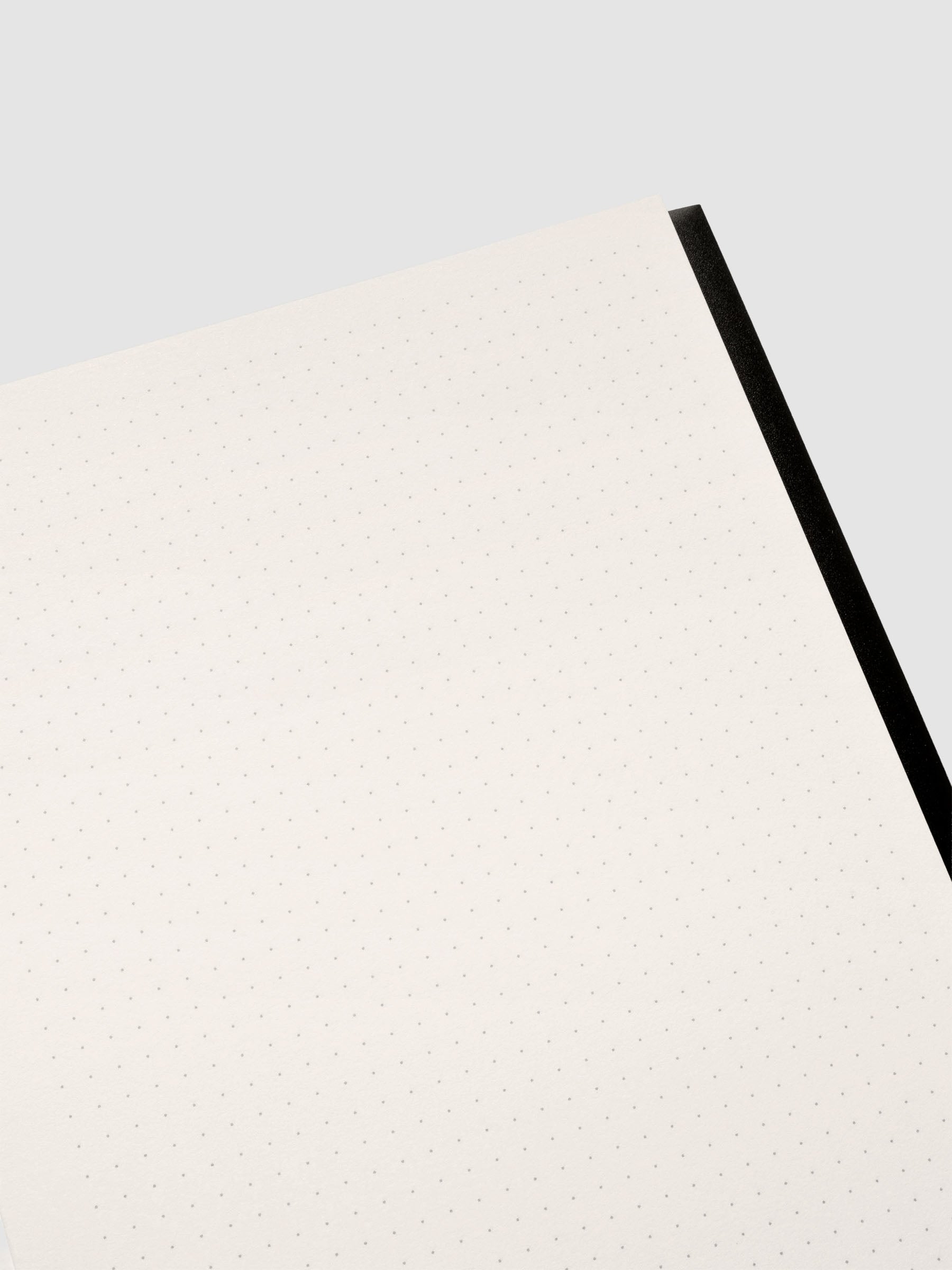 Close up of the Perfect Bound Notebook | A5 | Dot Grid | Avant Garde shown open, laying flat, displaying the dot grid layout.