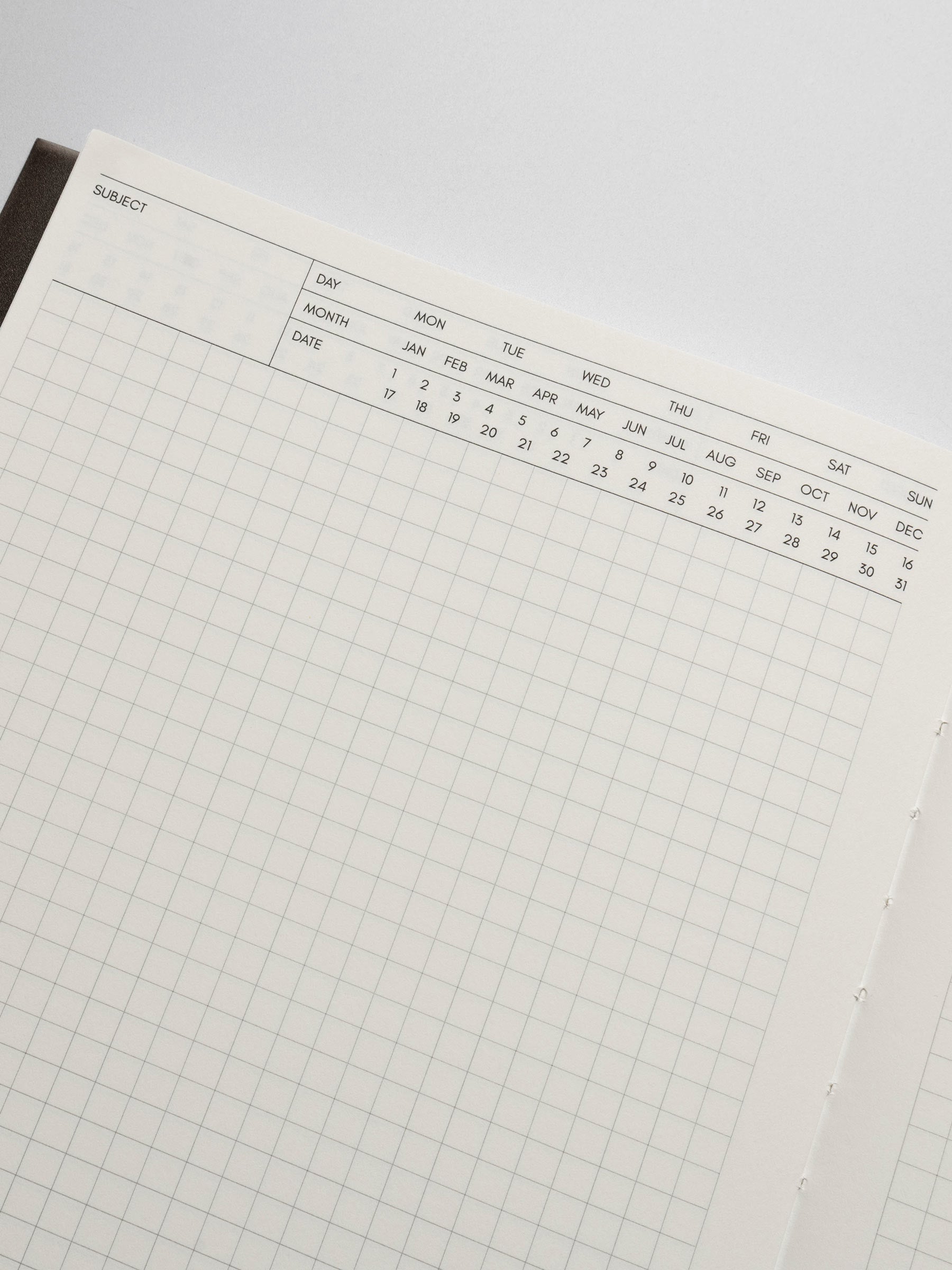 Perfect Bound Notebook in size HP Classic with Executive Notes pages shown close up to display the fields to write subject and mark day, month, and date with open grid note space for note taking below.