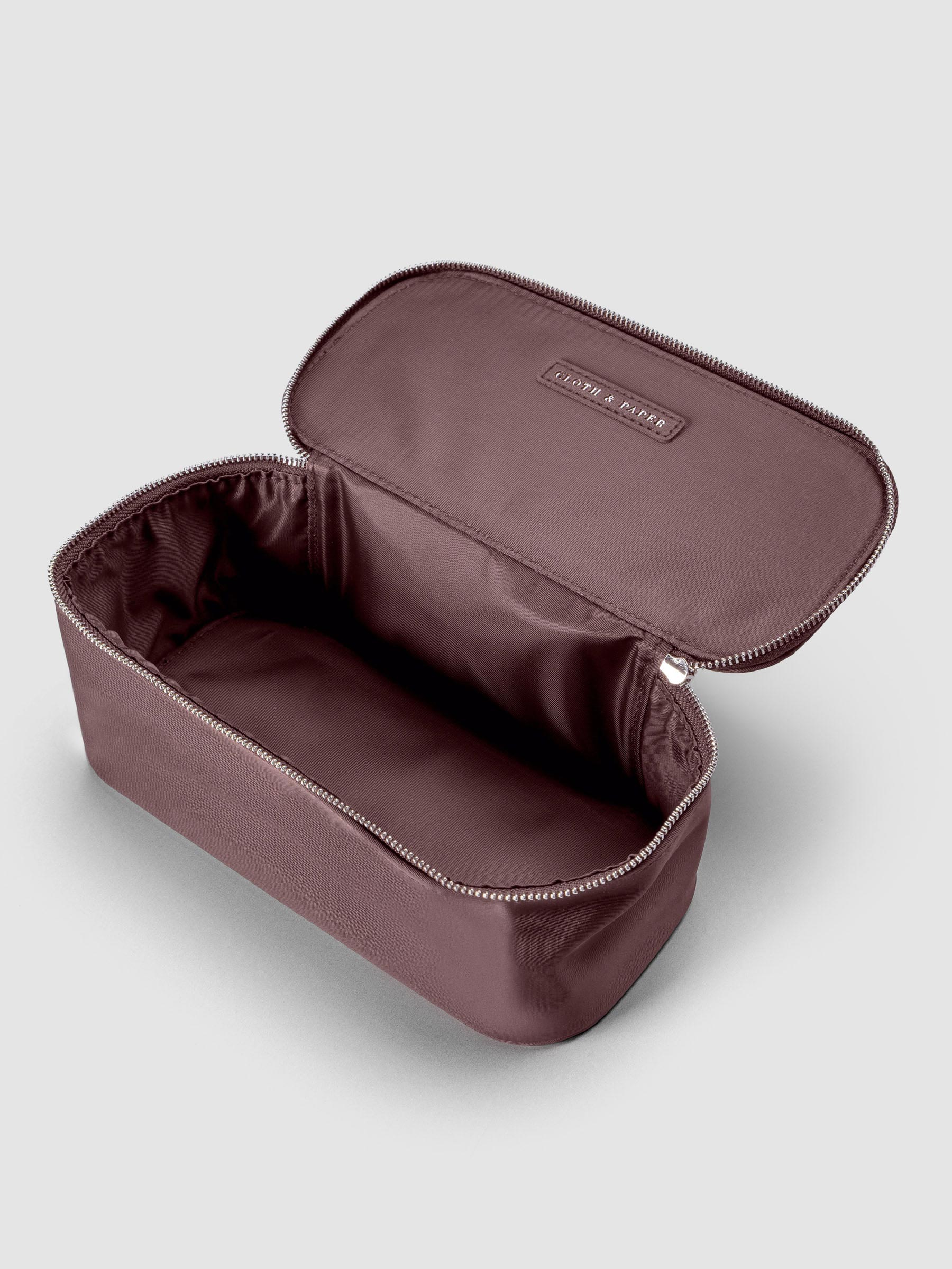 Small packing cube in the color walnut shown unzipped and open against a neutral background; shown at an angle.