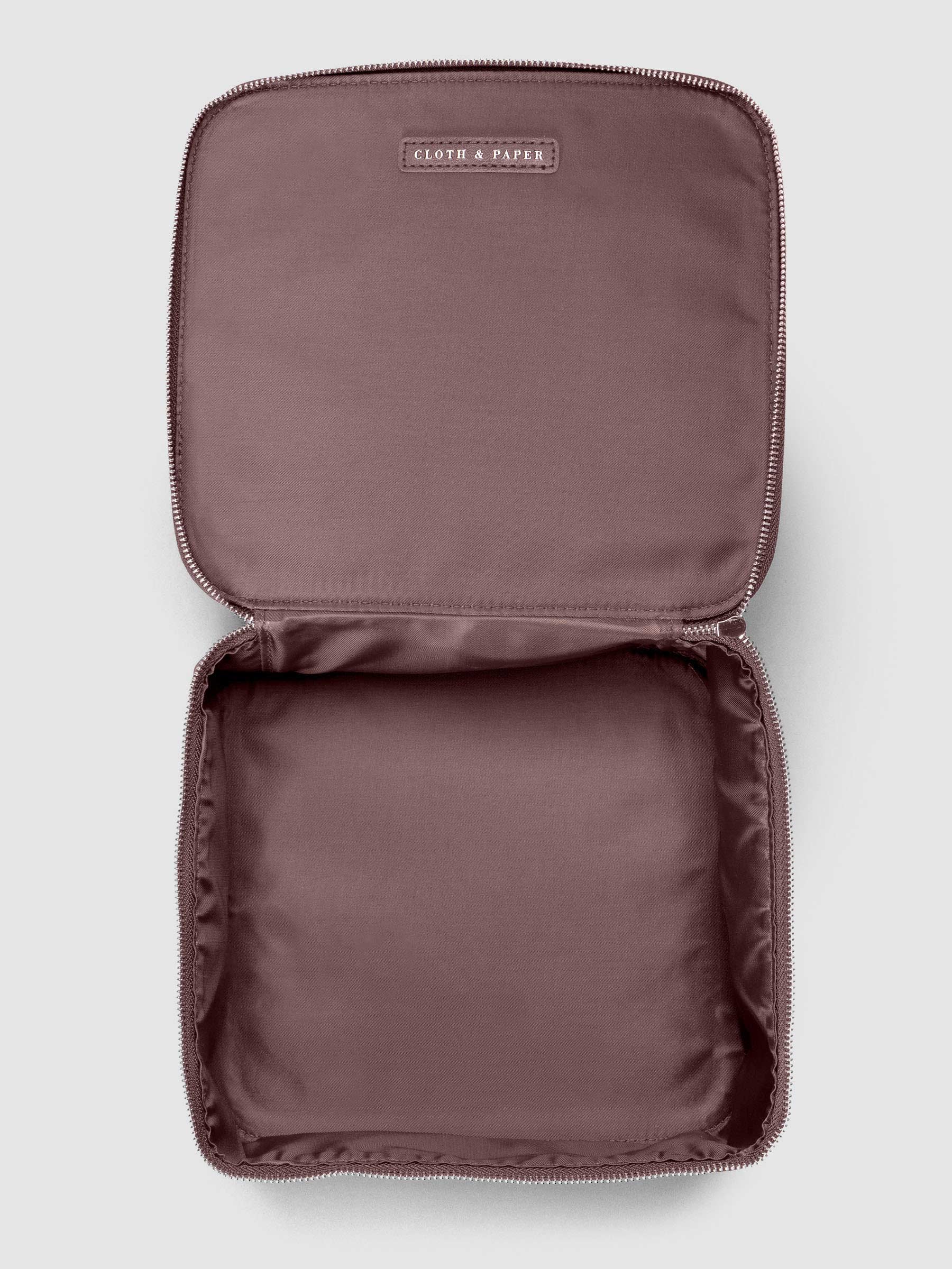 Medium packing cube shown unzipped and open in the color walnut against a neutral background.