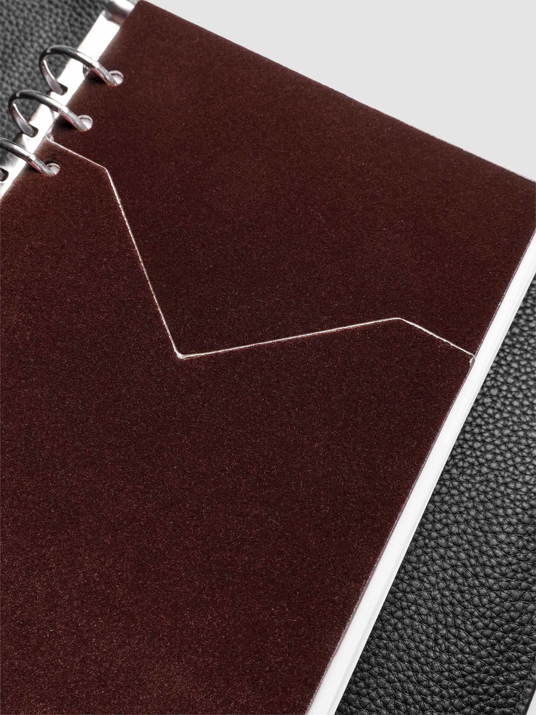 Velvet Pocket Folder in Bordeaux pre-punched for A5 planners shown in a black leather agenda.