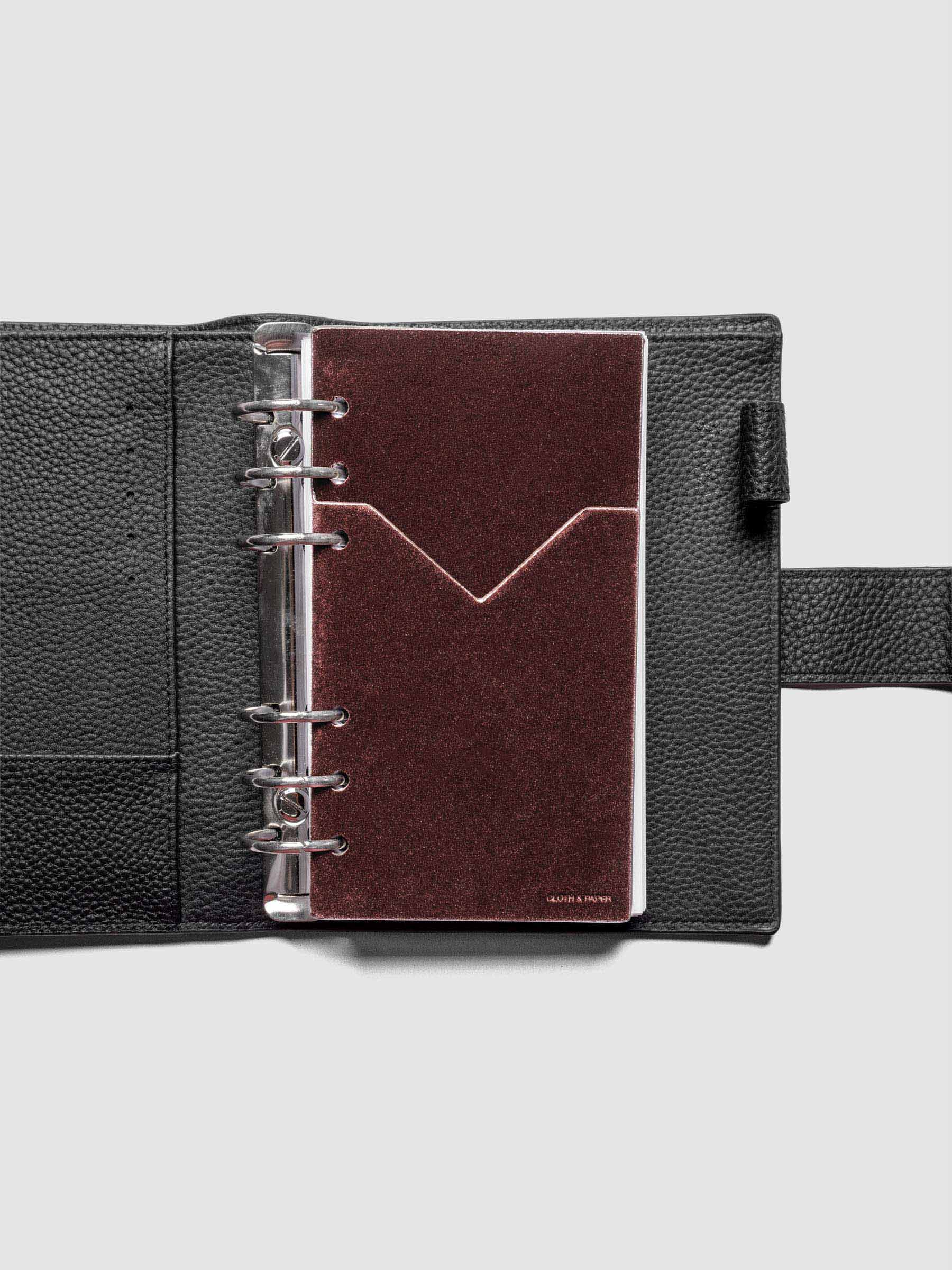 Velvet Pocket Folder in Bordeaux pre-punched for Pocket planners shown in a black leather agenda.