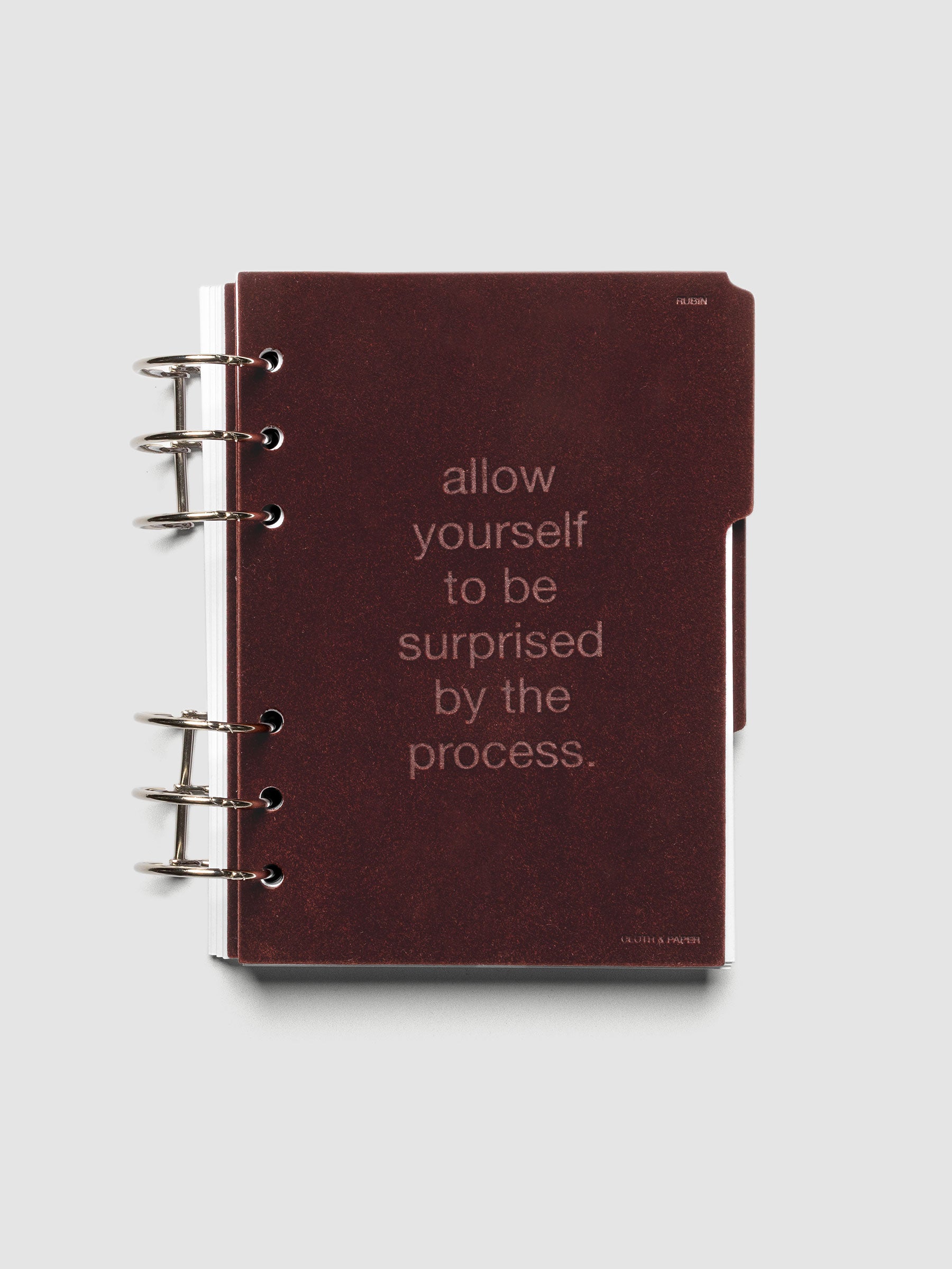First velvet side tab planners dividers in the color Bordeaux with text deboss design reading "allow yourself to be surprised by the process" in size Personal Wide shown ringbound.