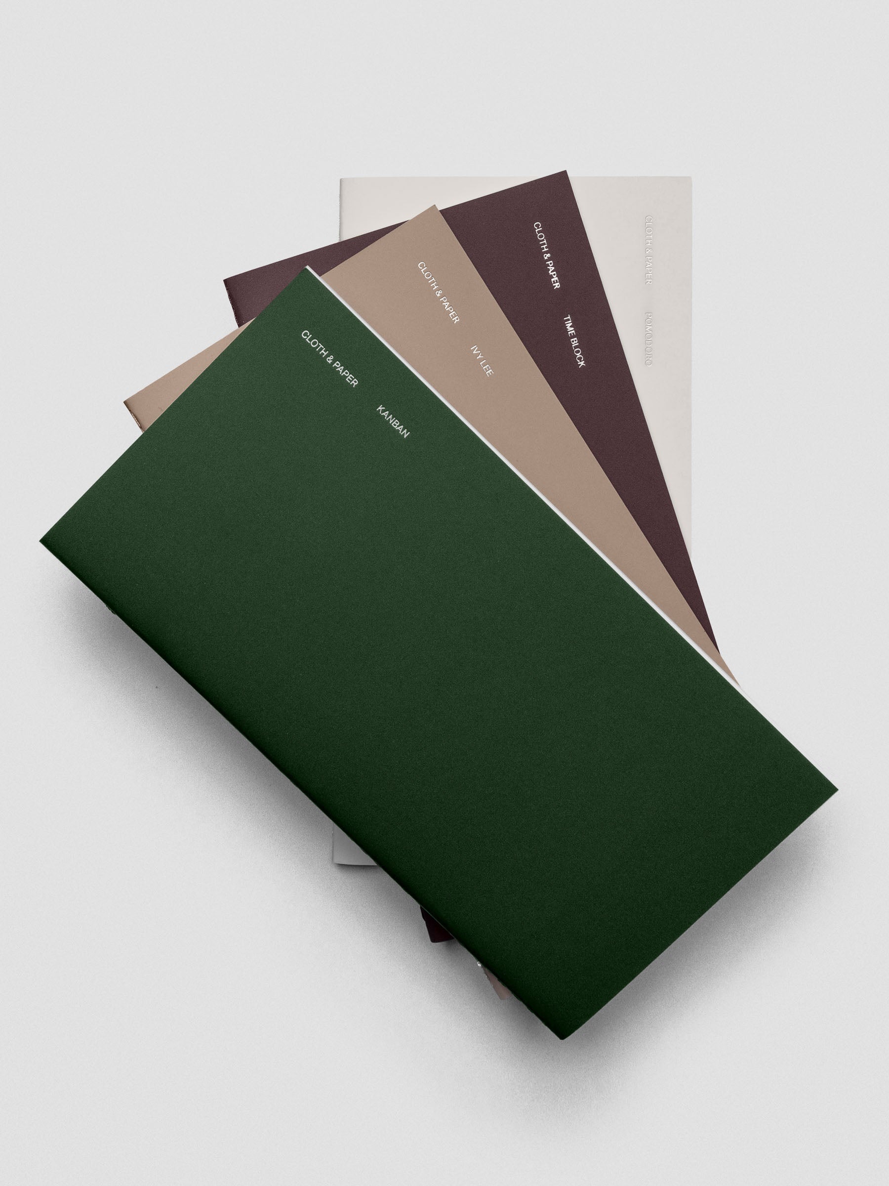 Set of four A5 Slim planning notebooks stacked together on a desk.