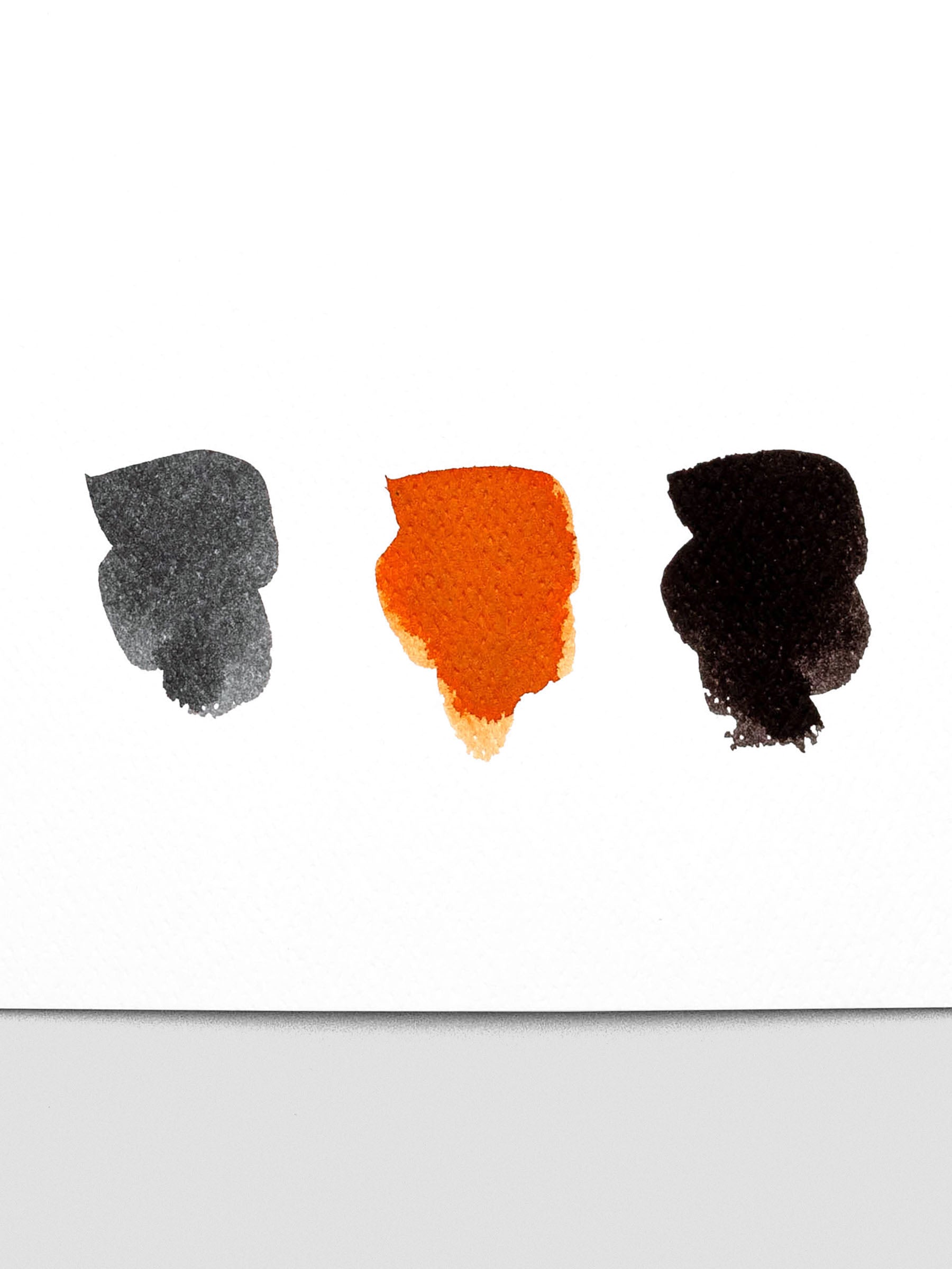 Ink swatches on paper from left to right of Dove Grey, Marmalade, and Deep Black Tom's Studio Fountain Pen Ink.