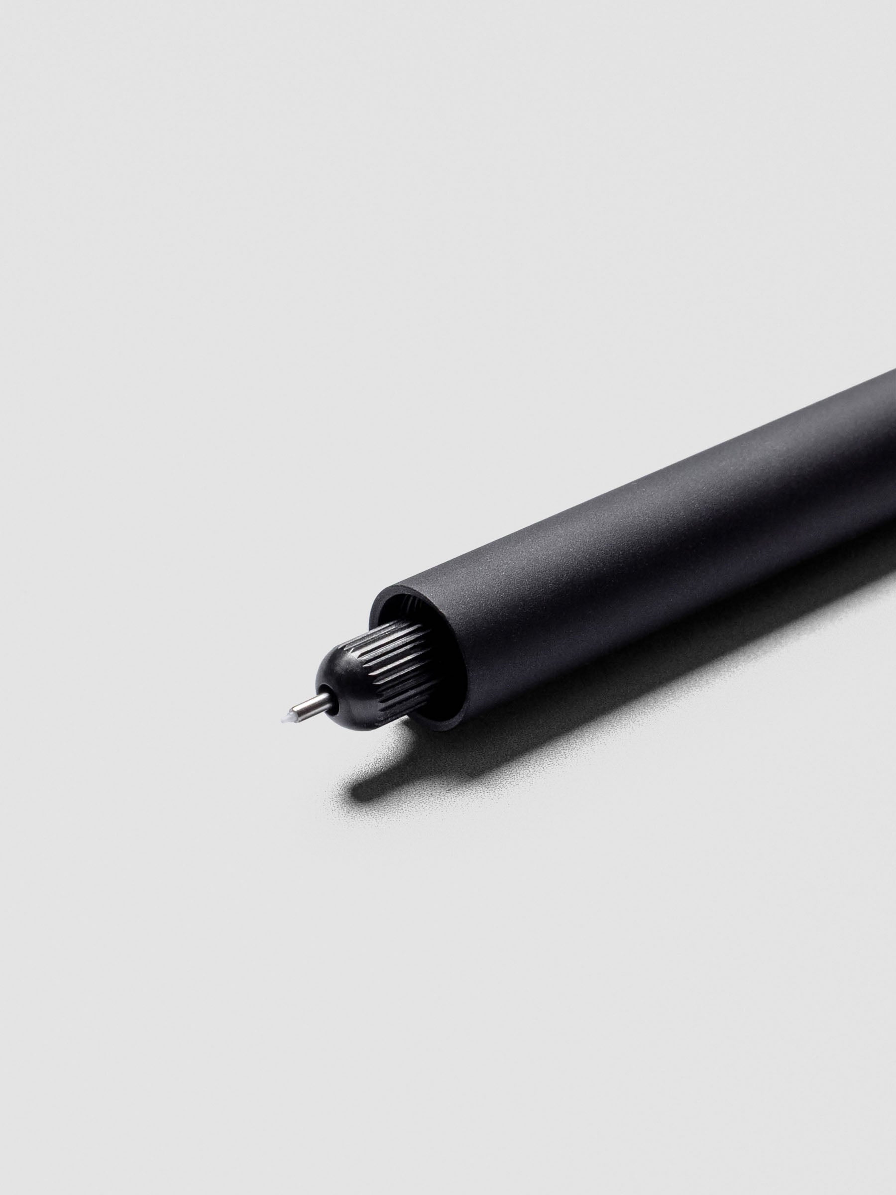Close-up of uncapped Matte Black Lumos Pro Duo Tip Pen with writing tip visible.