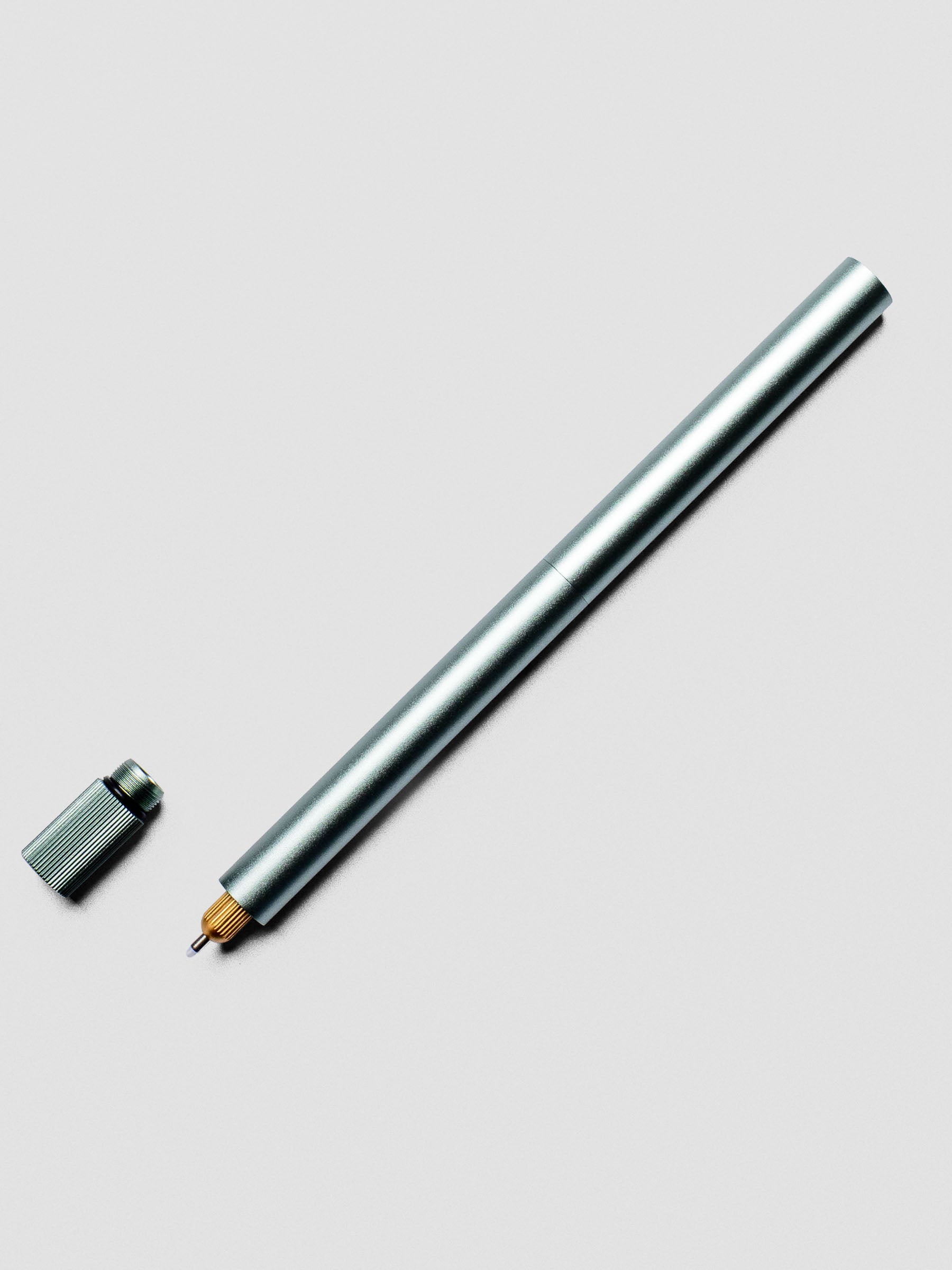 Sage Green Lumos Pro Duo Tip Pen placed beside its cap on an neutral background.