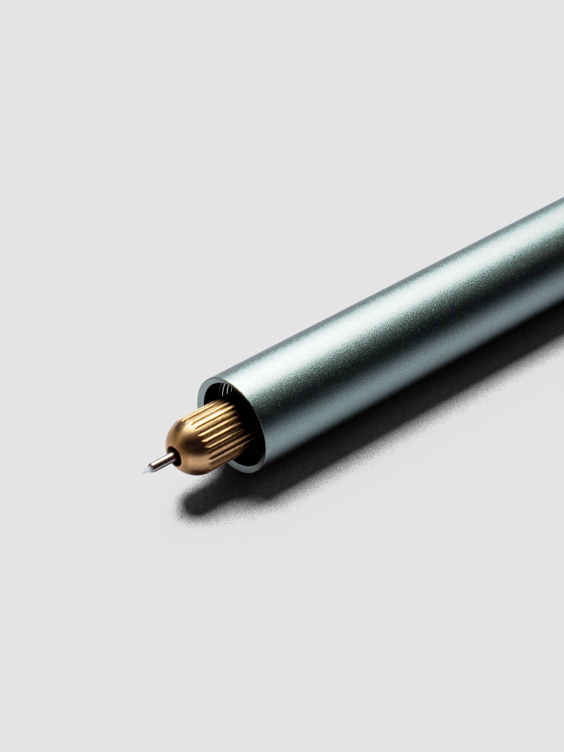 Close-up of Sage Green Lumos Pro Duo Tip Pen angled across a notebook page, uncapped on both ends.