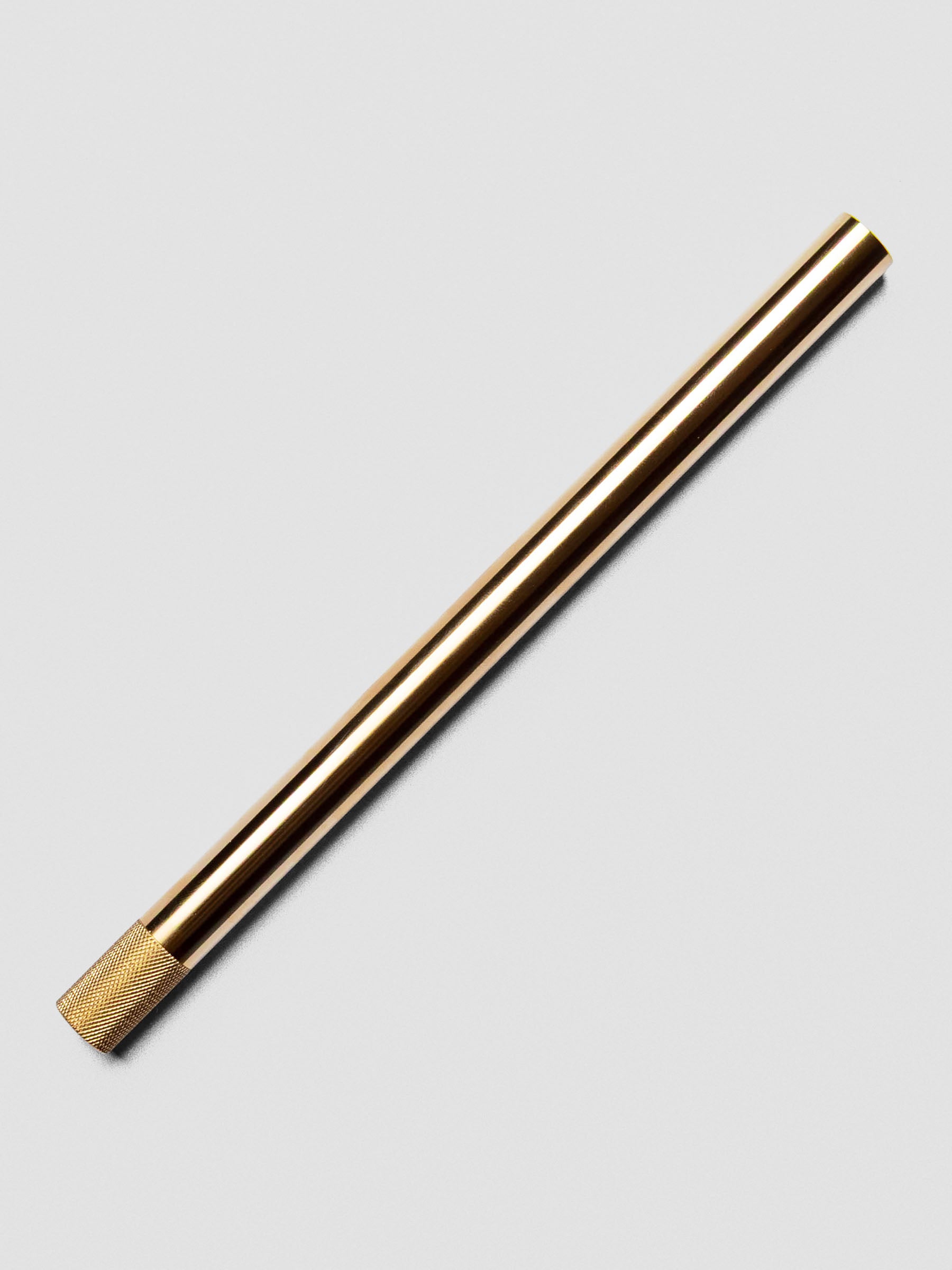 Brass Lumos Pro Pen resting diagonally, capped.
