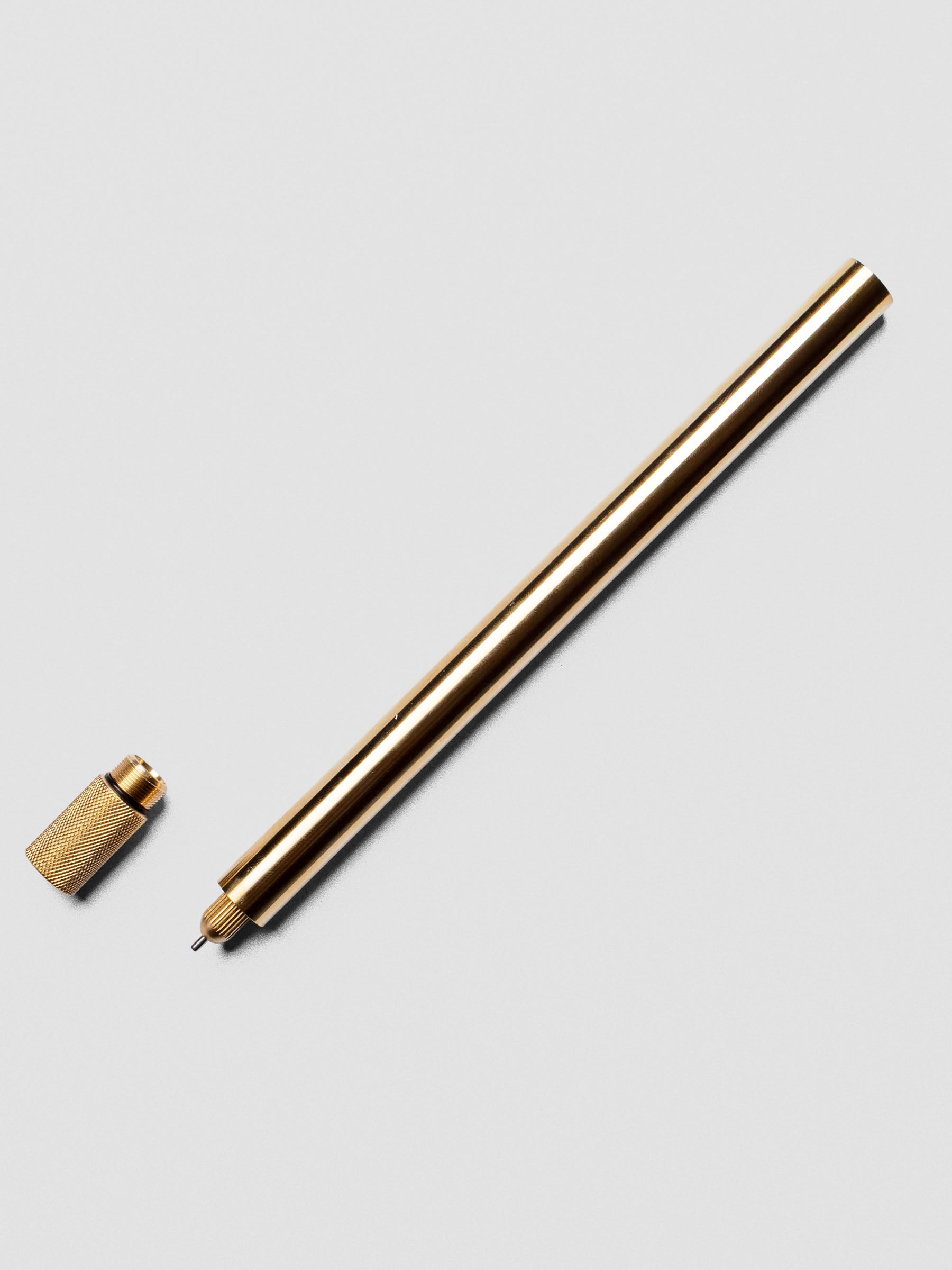 Uncapped Brass Lumos Pro Pen with tip exposed.