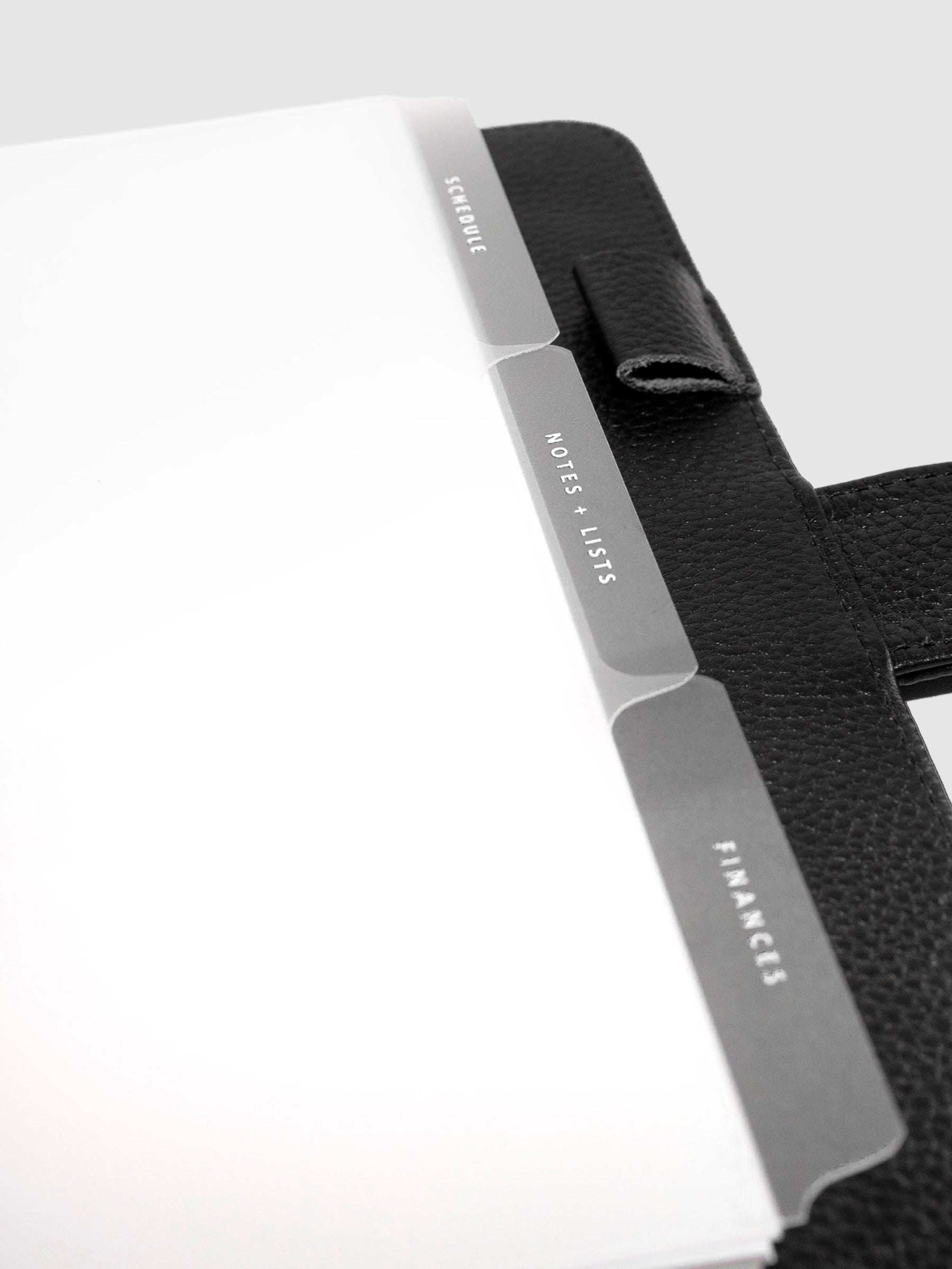 The Essentials Side Tab Planner Dividers, Glass Plastic, White Foil, Cloth and Paper. Close up on dividers inside planner.