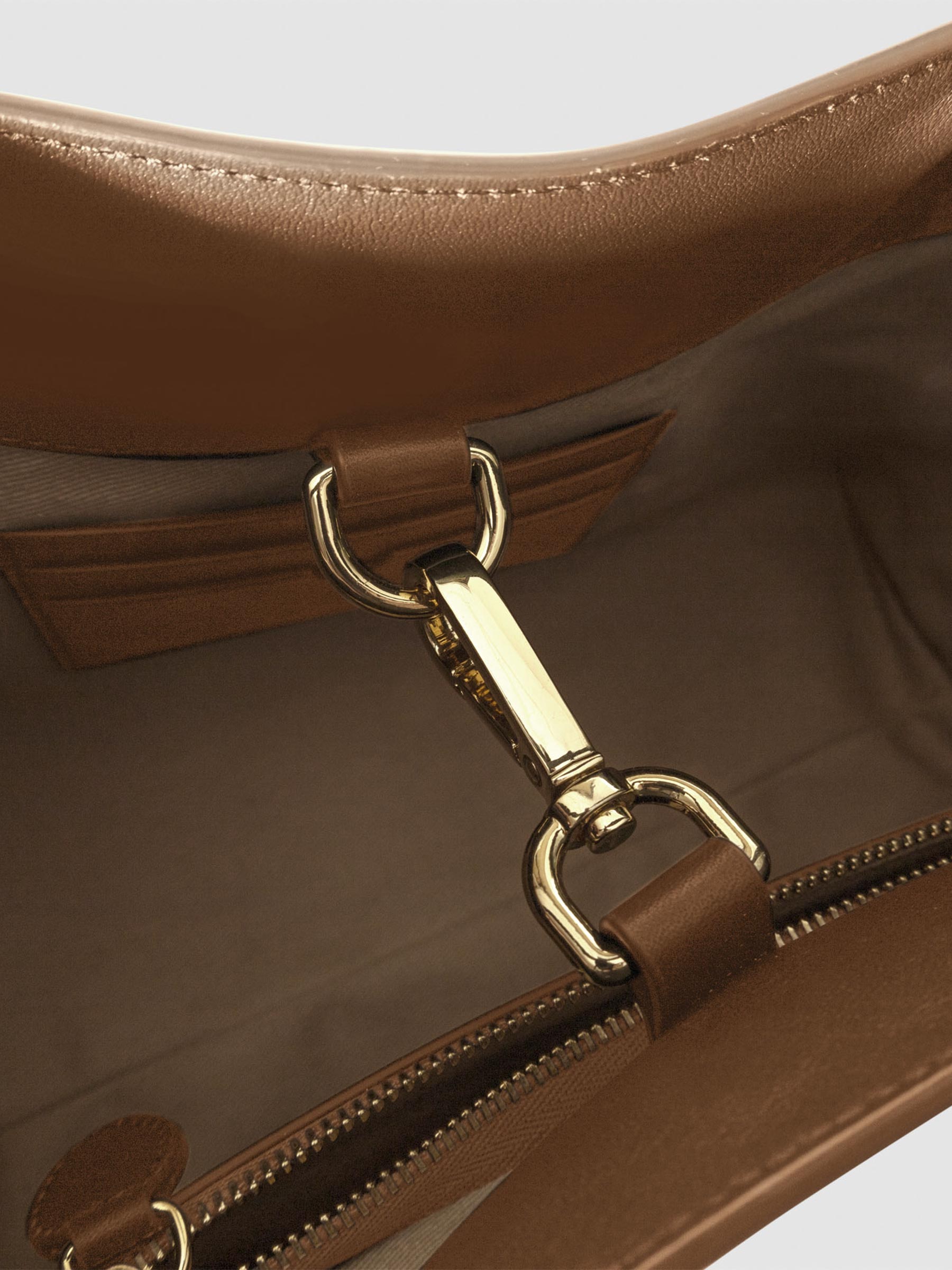 Top down view of bag showcasing its gold hardware. It secures the bag shut. Color shown is Alhambra.