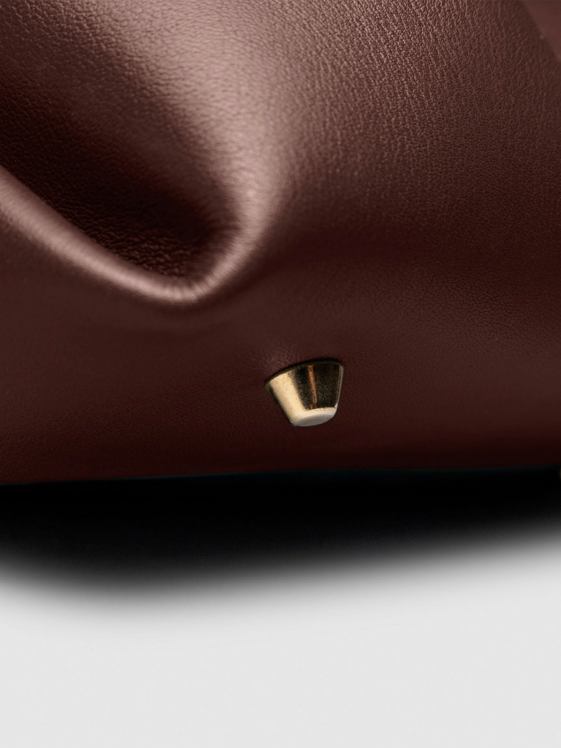Closeup of the gold feet on the bottom of the bag. Color shown is Cordoba.