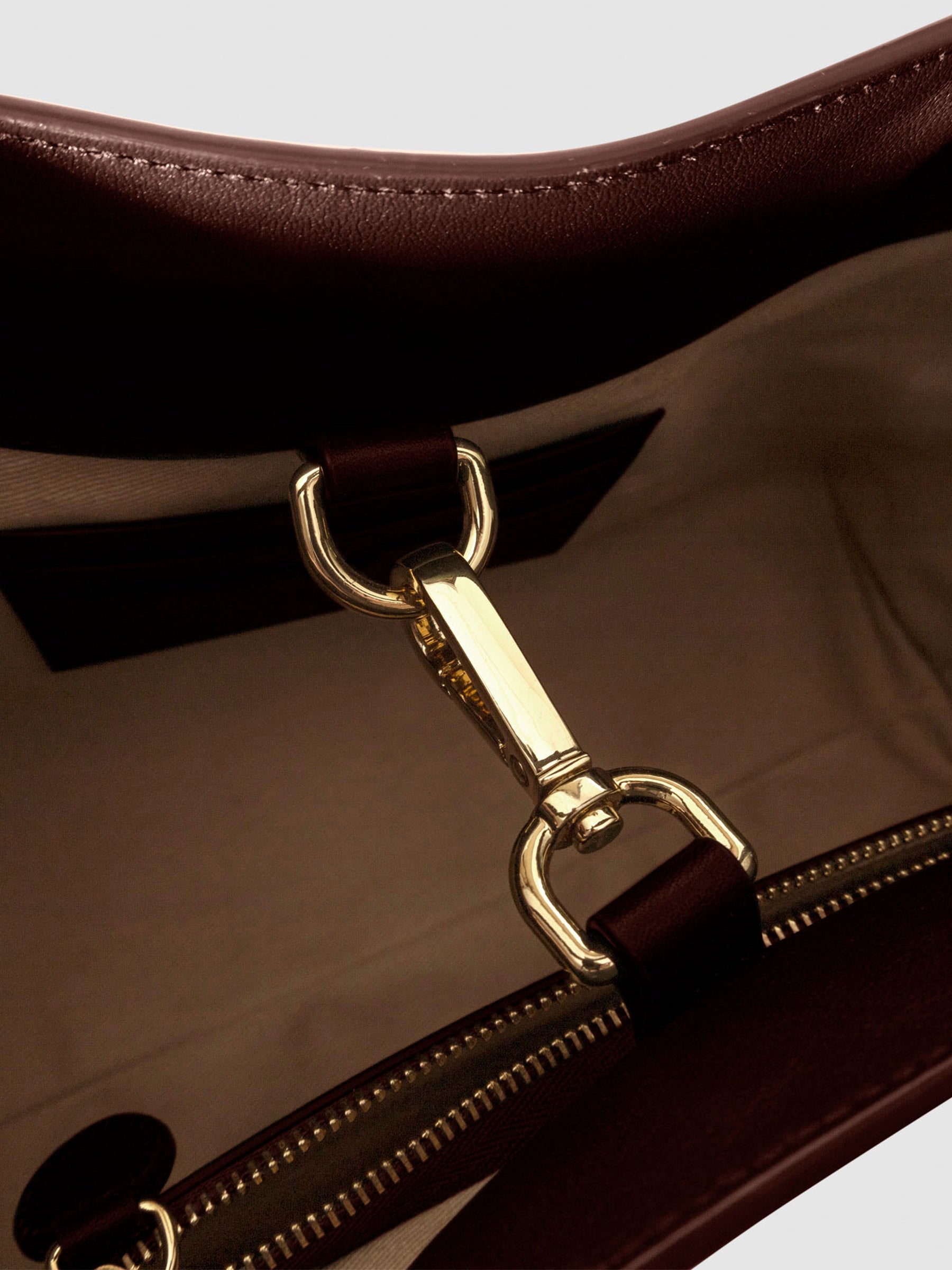 Top down view of bag showcasing its gold hardware. It secures the bag shut. Color shown is Cordoba.