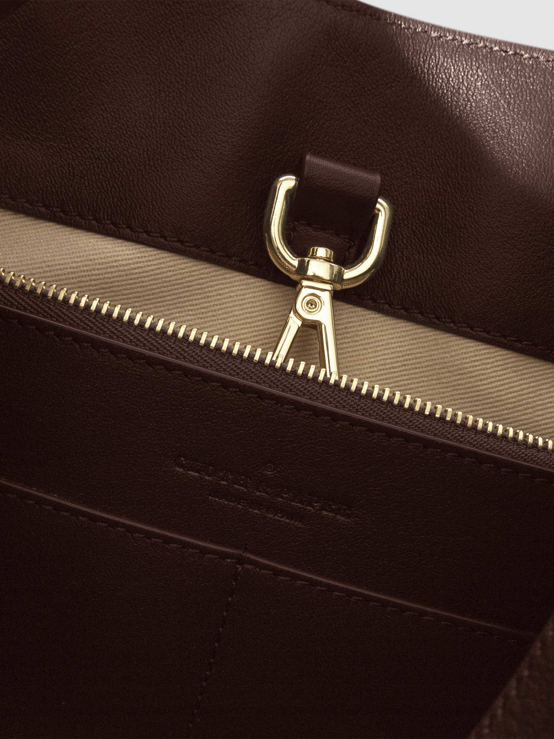 Top down view of bag showcasing its gold hardware. It secures the bag shut. Color shown is Cordoba.