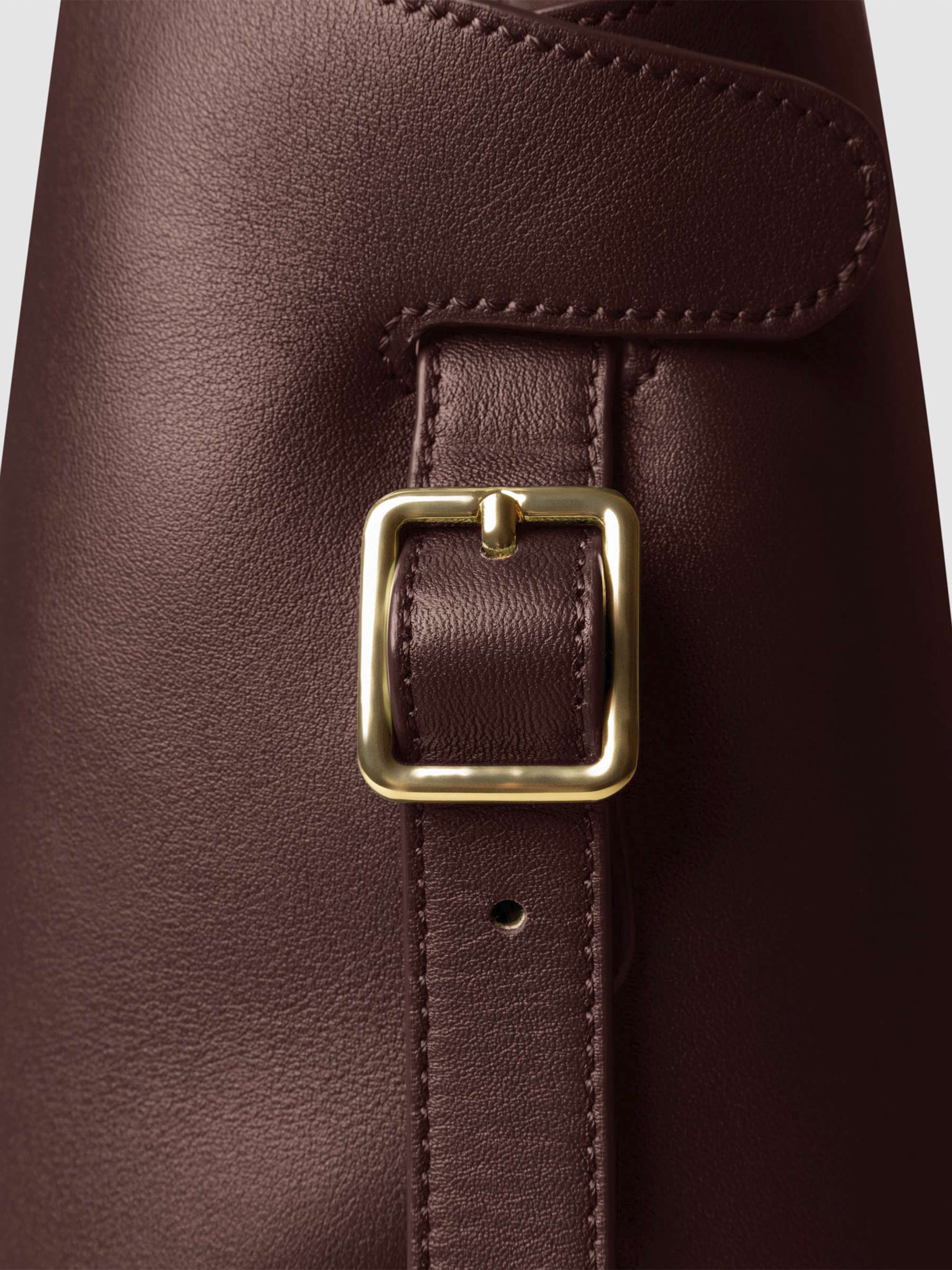 Side view of bag showcasing its gold hardware and adjustable leather strap. Color shown is Cordoba.