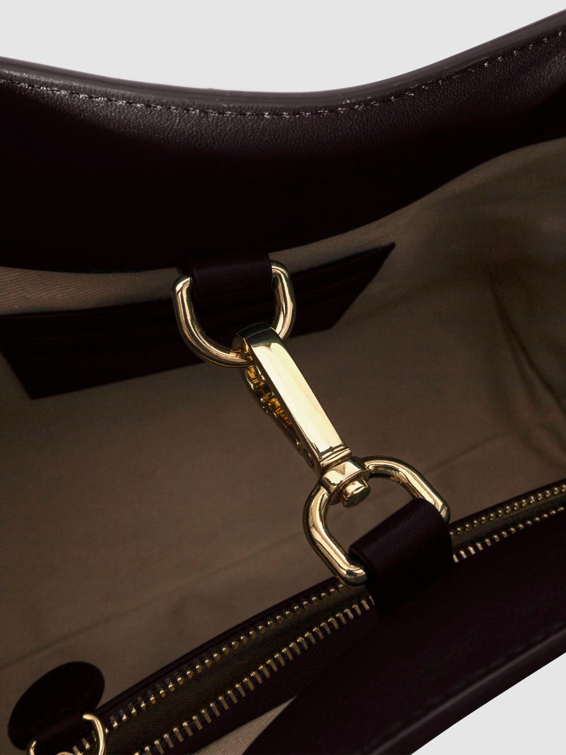 Top down view of bag showcasing its gold hardware. It secures the bag shut. Color shown is Madrid.