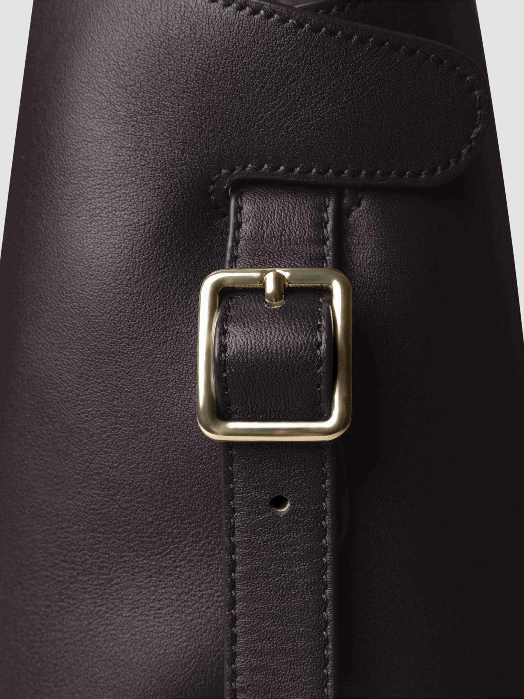 Side view of bag showcasing its gold hardware and adjustable leather strap. Color shown is Madrid.