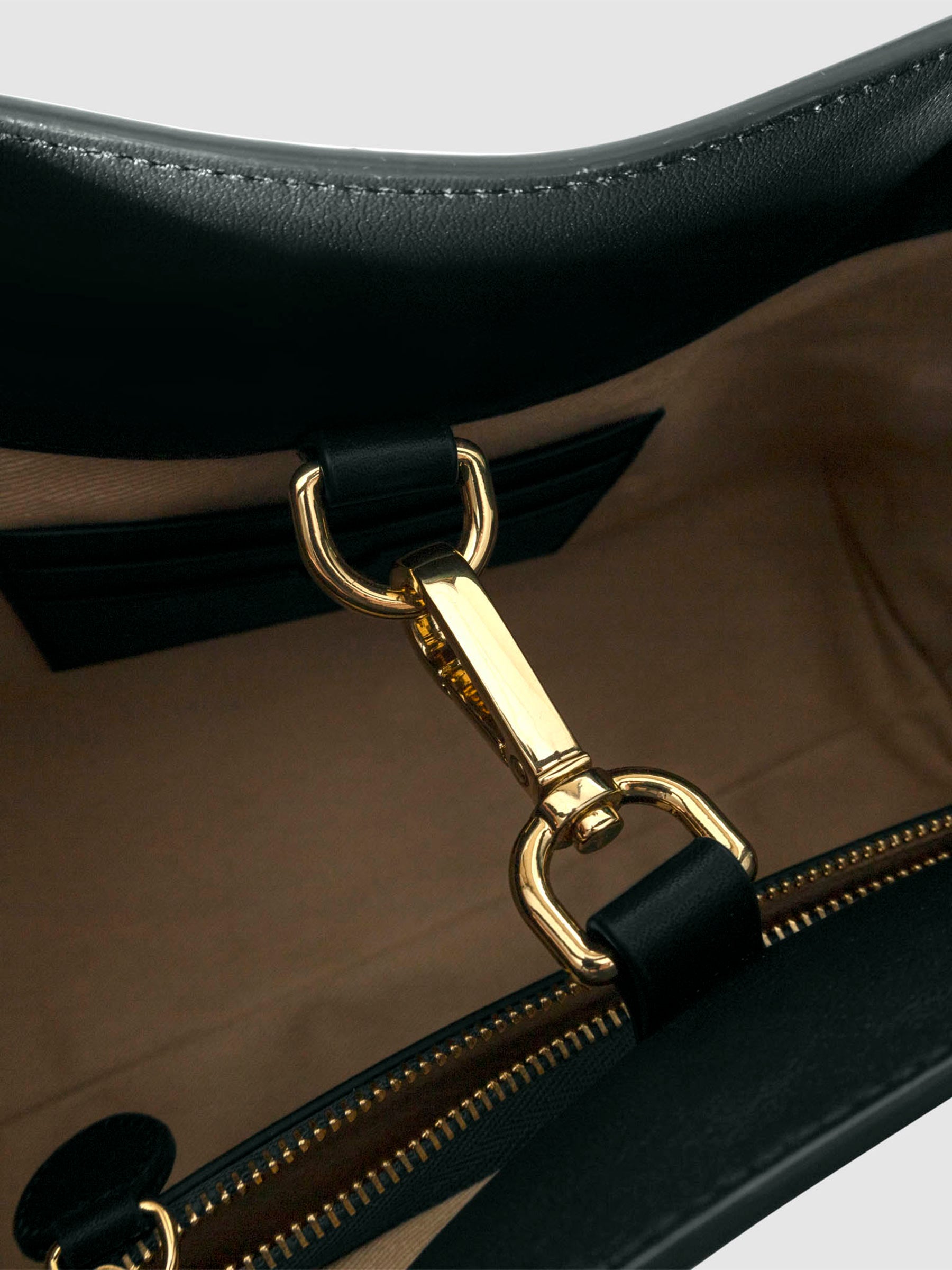 Top down view of bag showcasing its gold hardware. It secures the bag shut. Color shown is Salamanca.