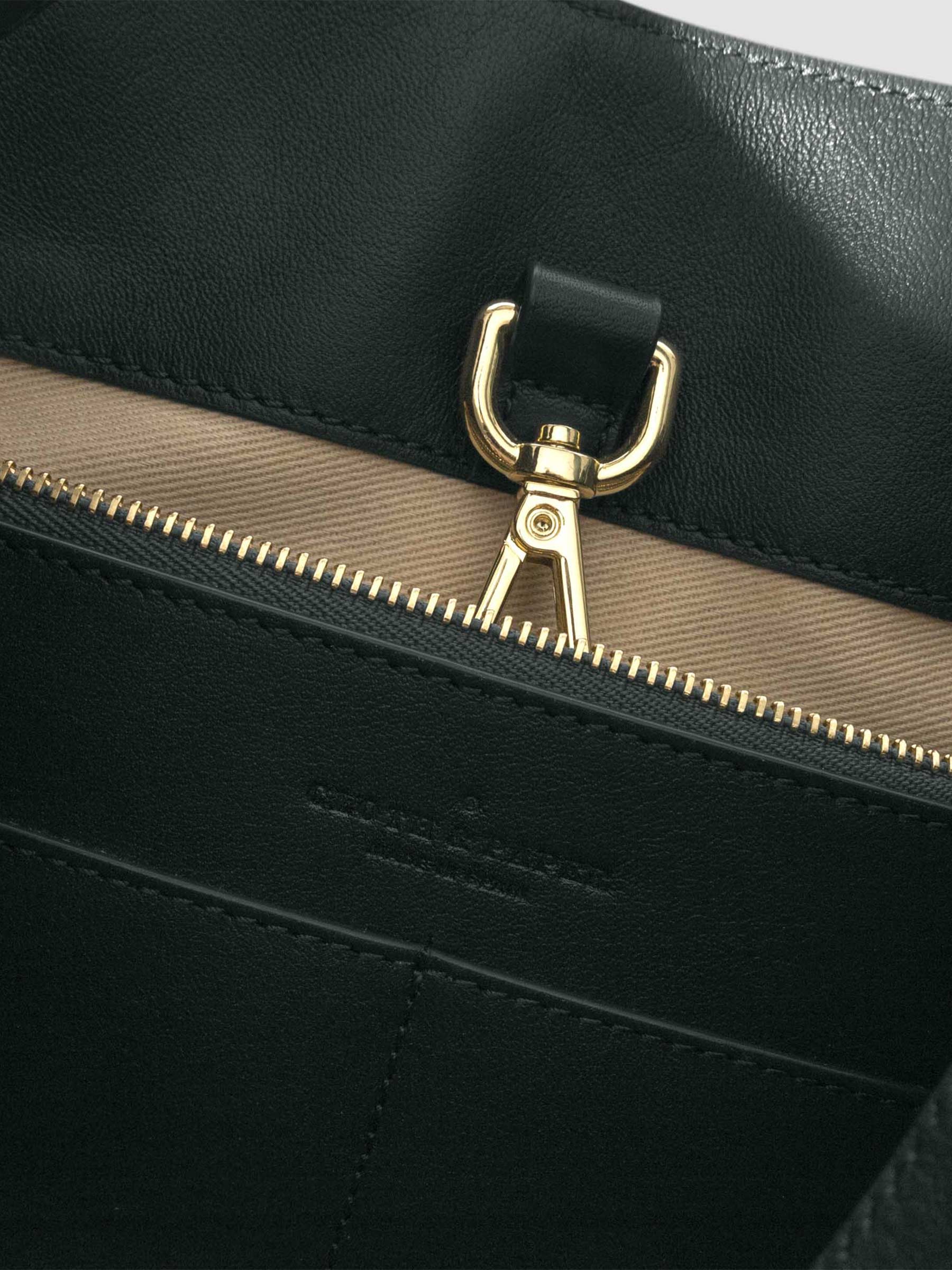 Top down view of bag showcasing its gold hardware. It secures the bag shut. Color shown is Salamanca.