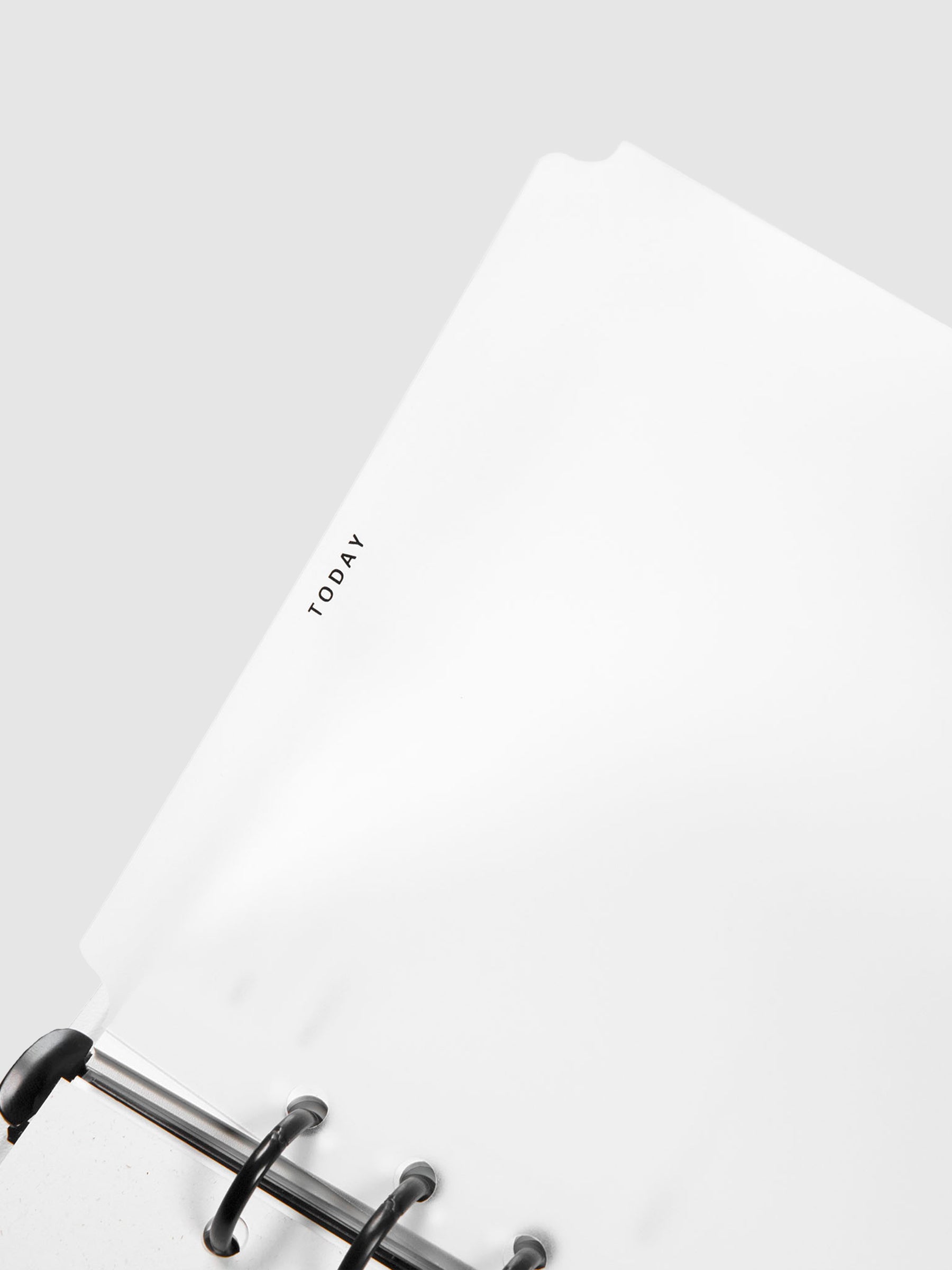 Today Dry Erase Tab Divider, Black Text, Cloth and Paper. Close up on divider as it is being turned inside a planner, showing the outline of the product against a neutral background.