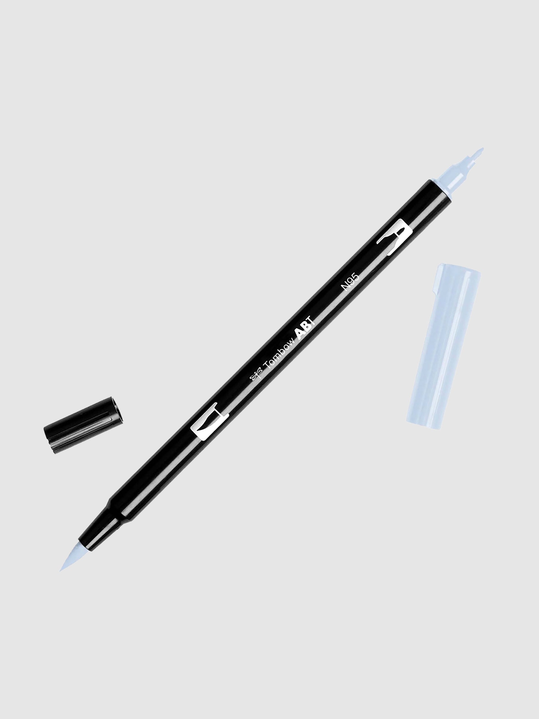 Tombow Dual Brush Art Marker, Cool Gray 1, Cloth & Paper. Art marker turned slightly to the right on a neutral background. It is uncapped on both ends showing the brush tip and fine tip.