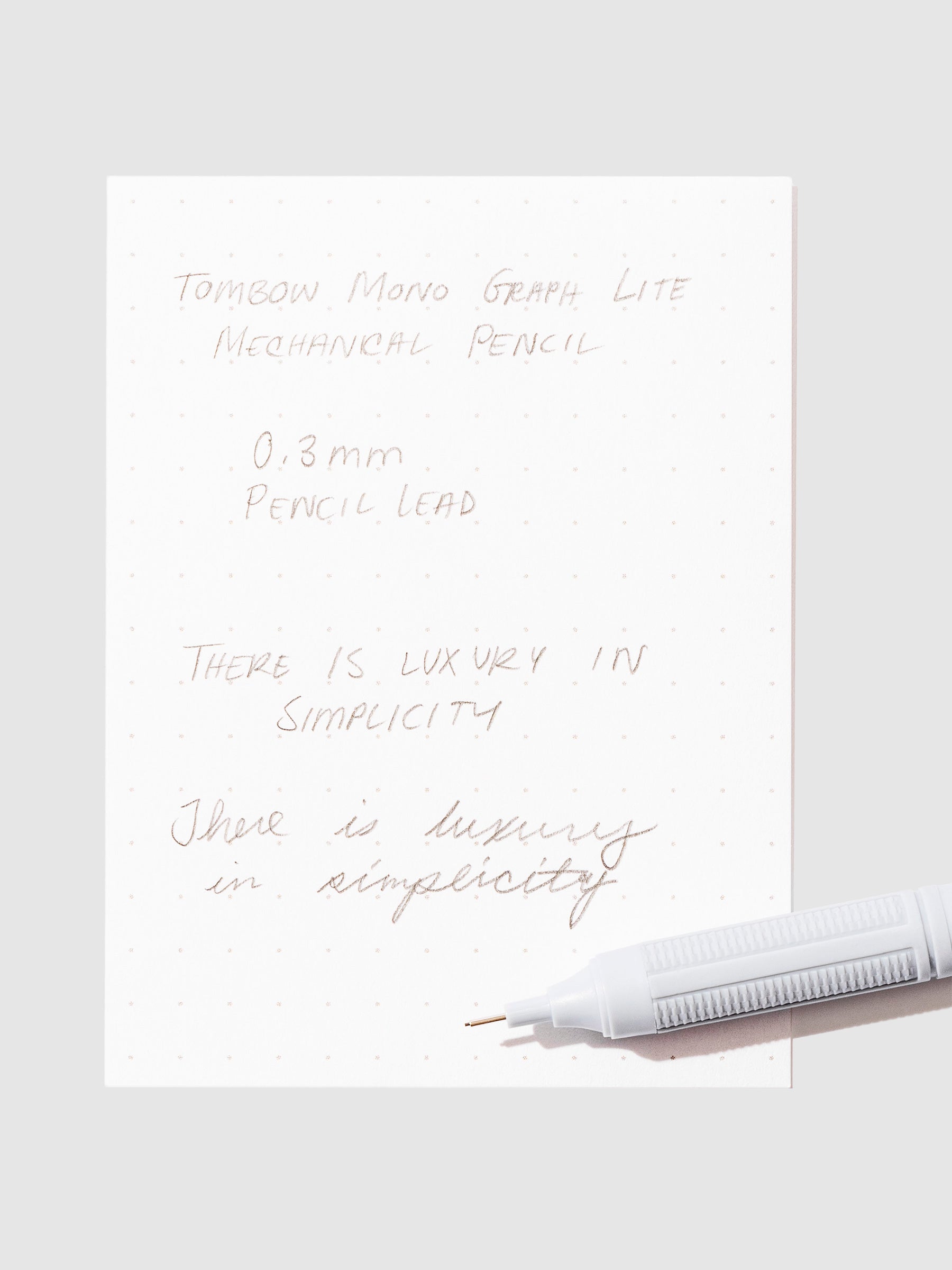 Writing sample with pencil displayed on a neutral background.