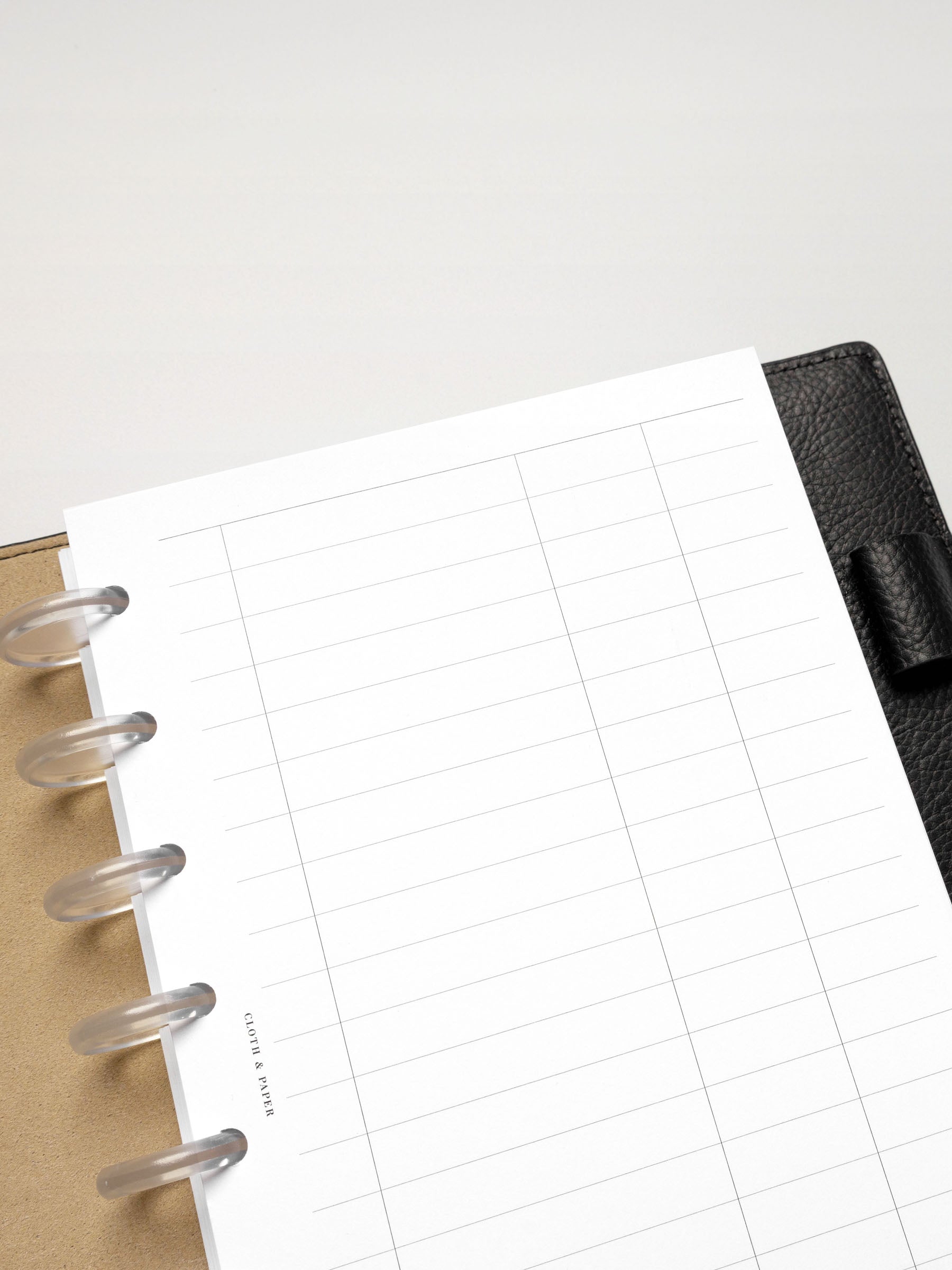 Angled view of the Half Letter-sized Tracker Planner Insert, emphasizing the minimalist grid and line structure.