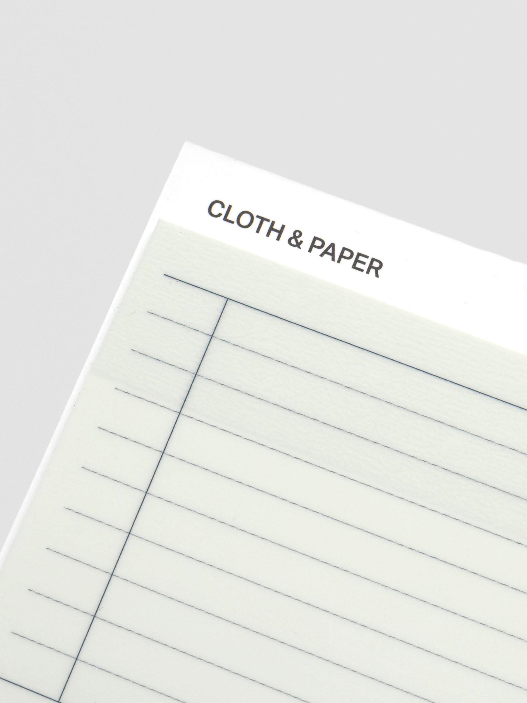 Close-up of the top corner of the transparent sticky note, highlighting the lined design and Cloth & Paper branding.